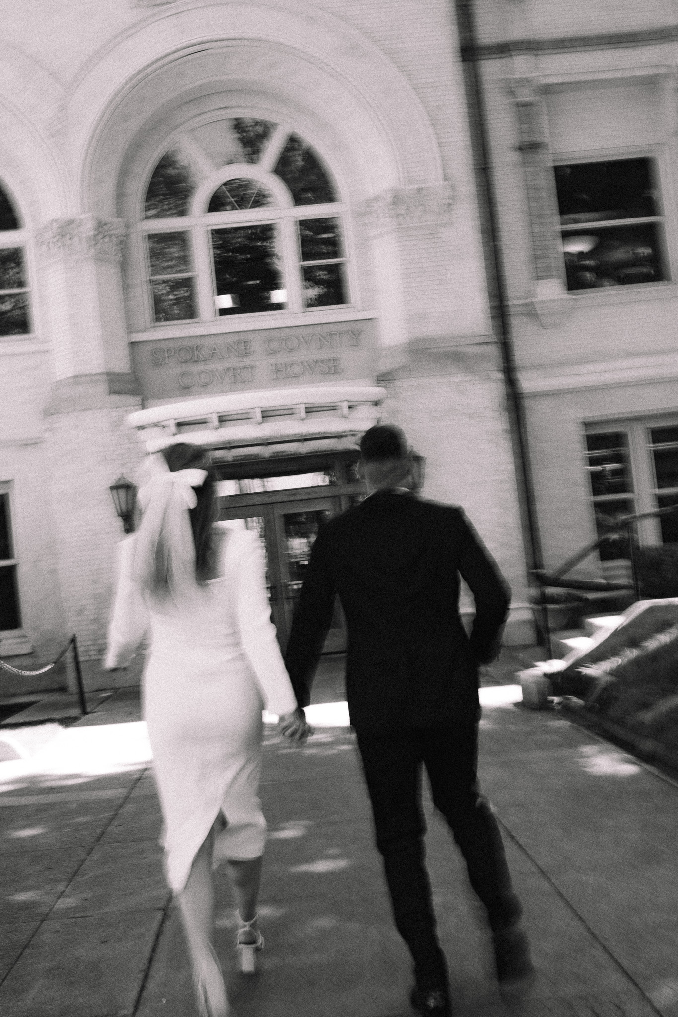 Bride and groom walking together towards a courthouse in Minnesota