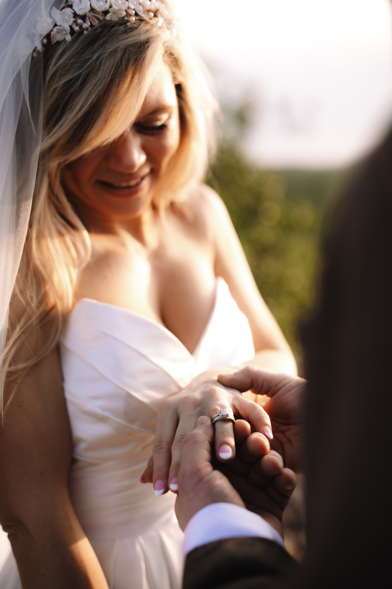 Groom putting his ring on his bride during their intimate safari wedding as the sun sets on their faces