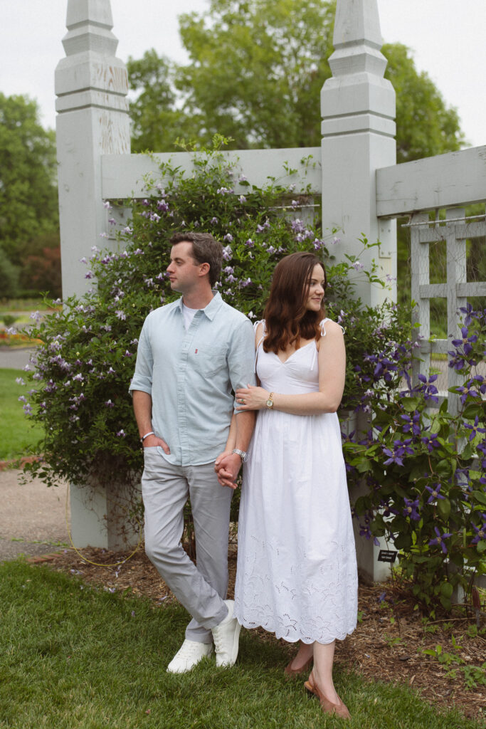 Engagement couple standing next to each other in a beautiful garden for their engagement photos at the Minnesota Landscape Arboretum