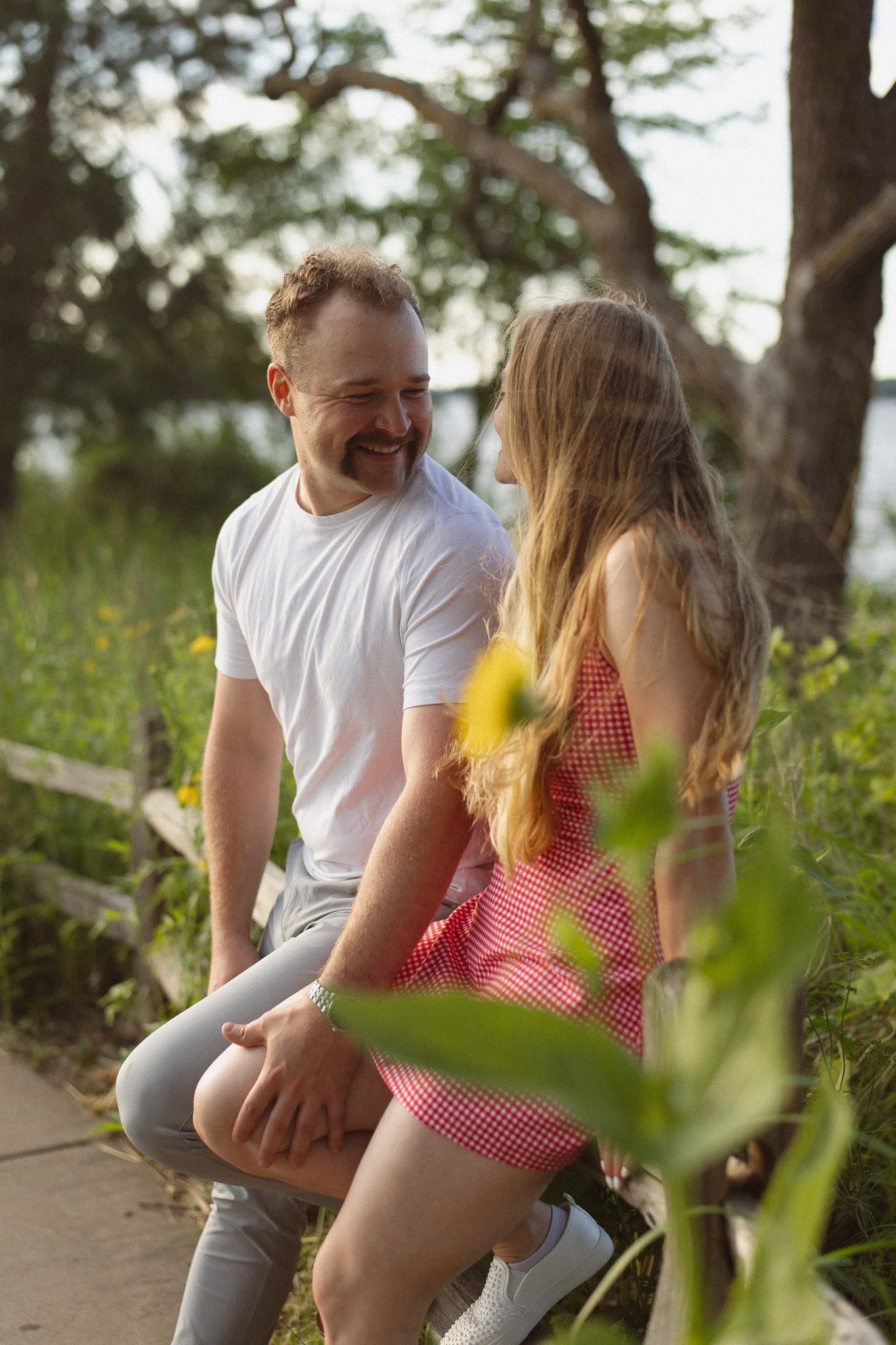 Couple sitting on a wooded fence in Excelsior during their engagement photos
