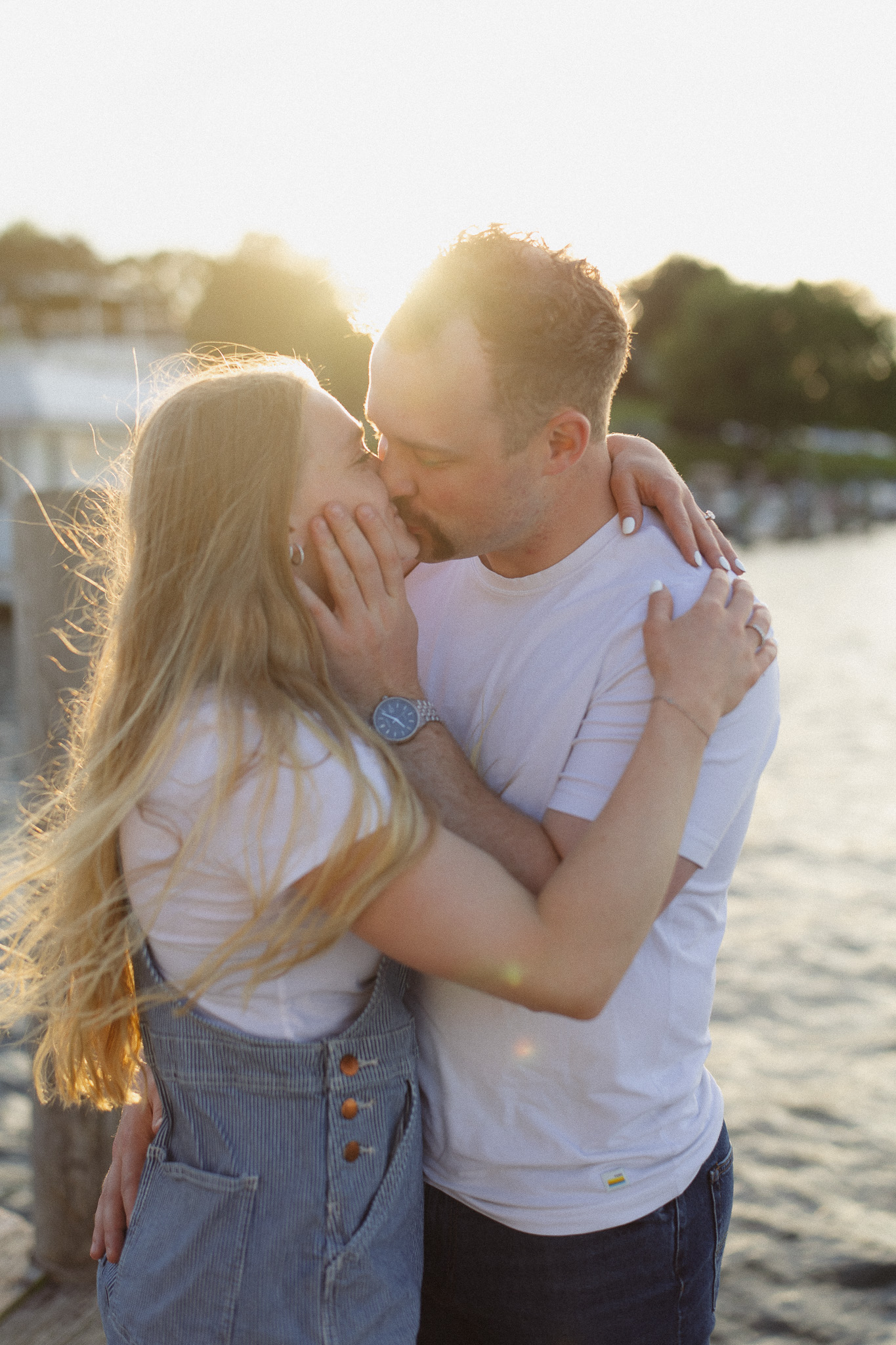 Couple kissing on the docks at Excelsior as the sun sets over Lake Minnetonka
