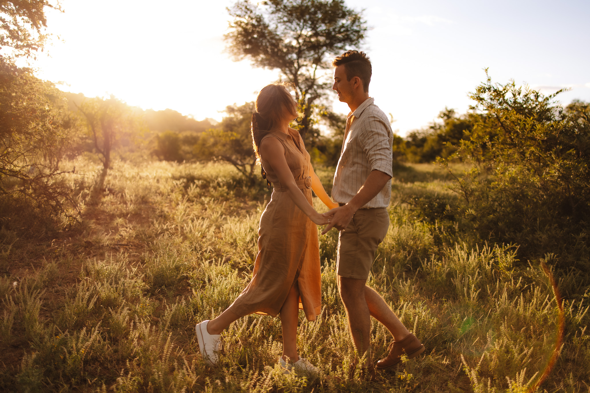 Guy and girl holding hands during golden hour at their engagement session in Purgatory park, Minnetonka- one of the best engagement photo locations in Minneapolis' west suburbs