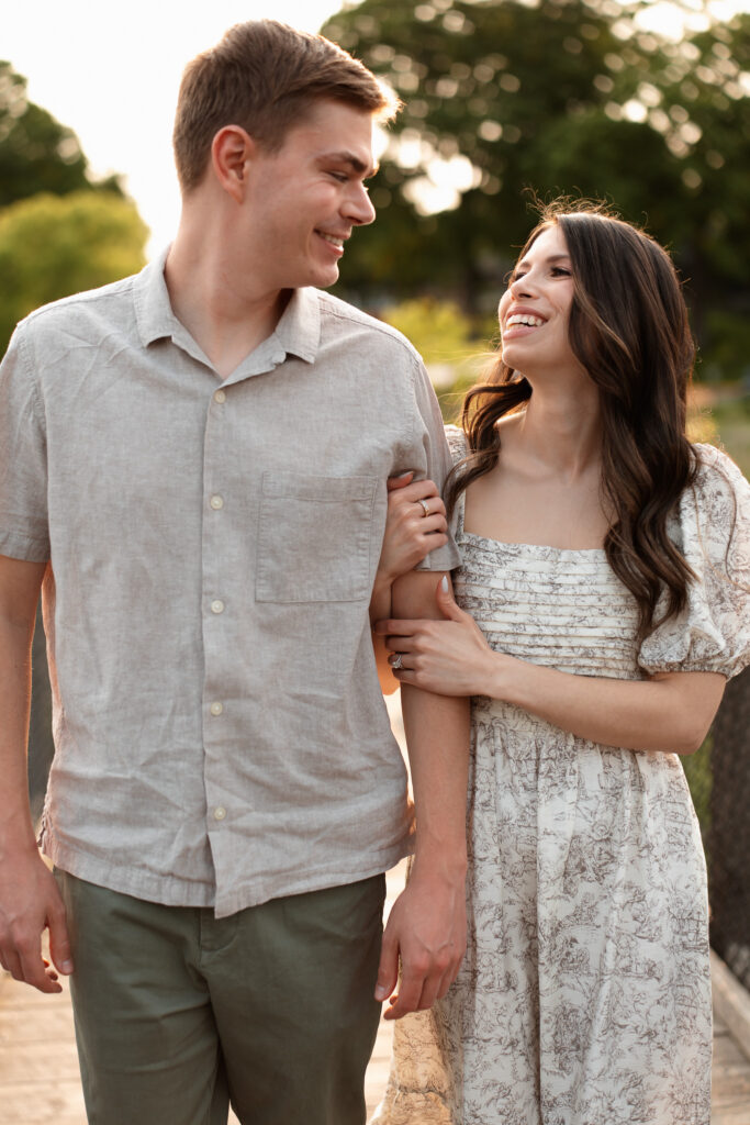 Engagement couple walking happily together in Wayzata for their engagement photos during golden hour