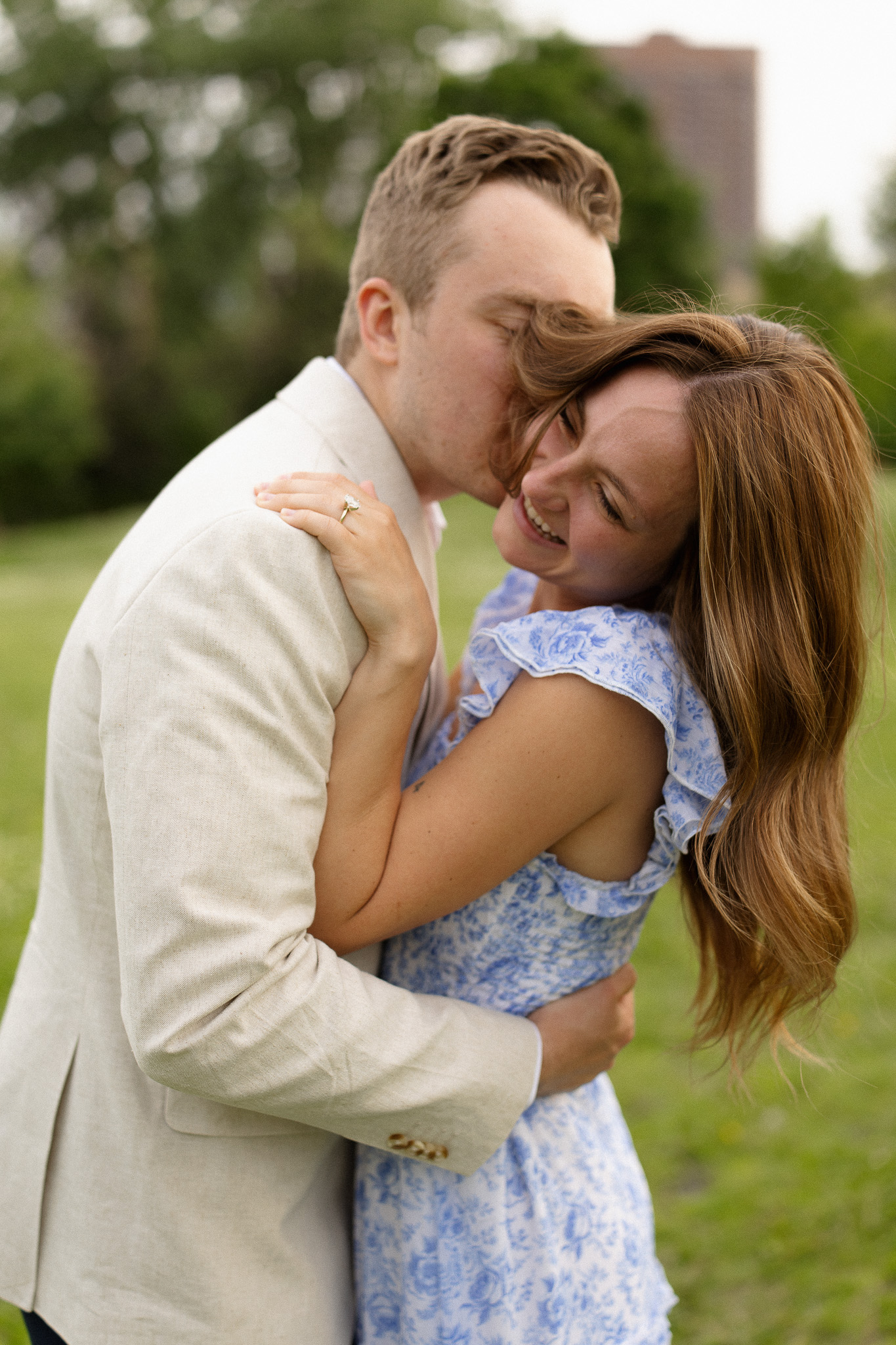 Guy kissing his girl's cheek during their engagement session at Nicollet Island in Minneapolis