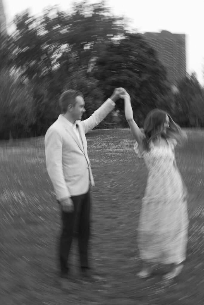 Documentary, cinematic style photo of engagement couple spinning on Nicollet Island