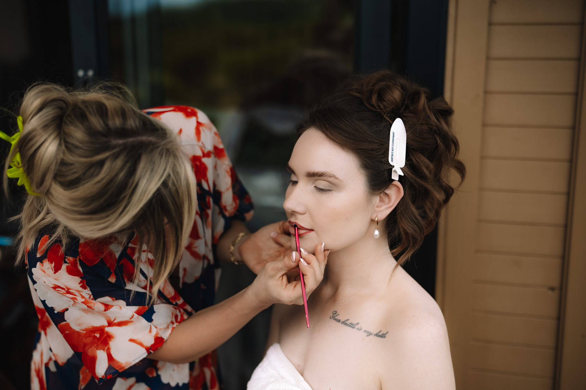 Bride having her makeup applied in her safari lodge suite before the ceremony