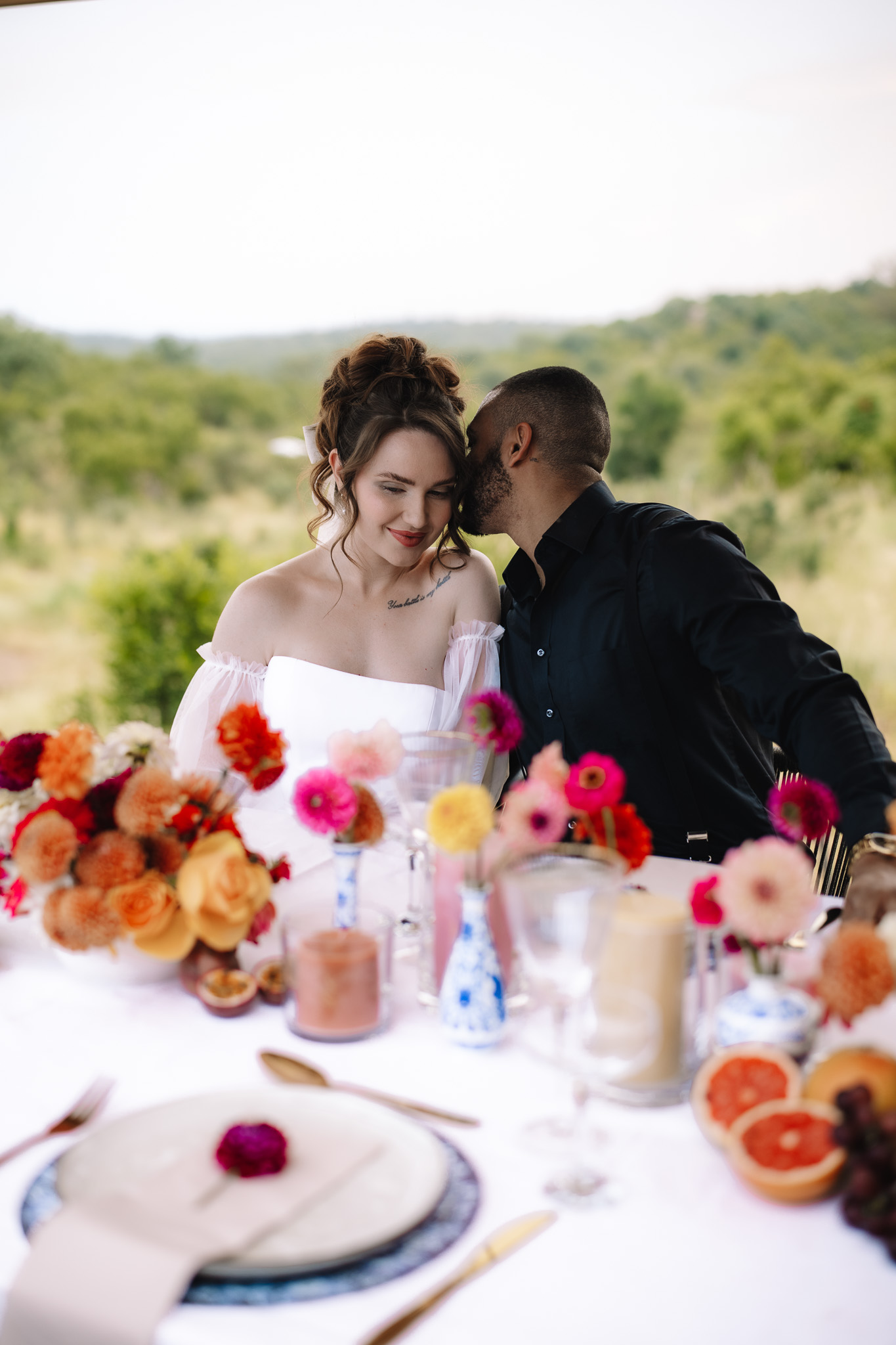 Bride and groom sitting at their beautiful table set up at a safari lodge in South Africa for their safari elopement