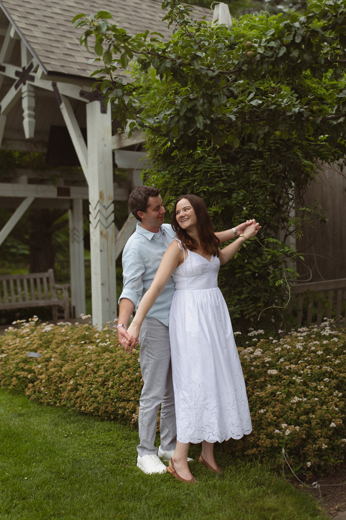 Engagement couple holding each other swaying there arms like an airplane at the Minnesota Landscape Arboretum