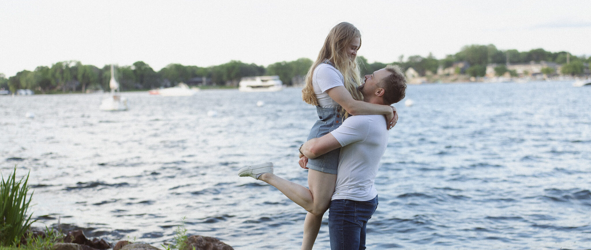 Girl jumping into her guy's arms during their engagement session in Excelsior
