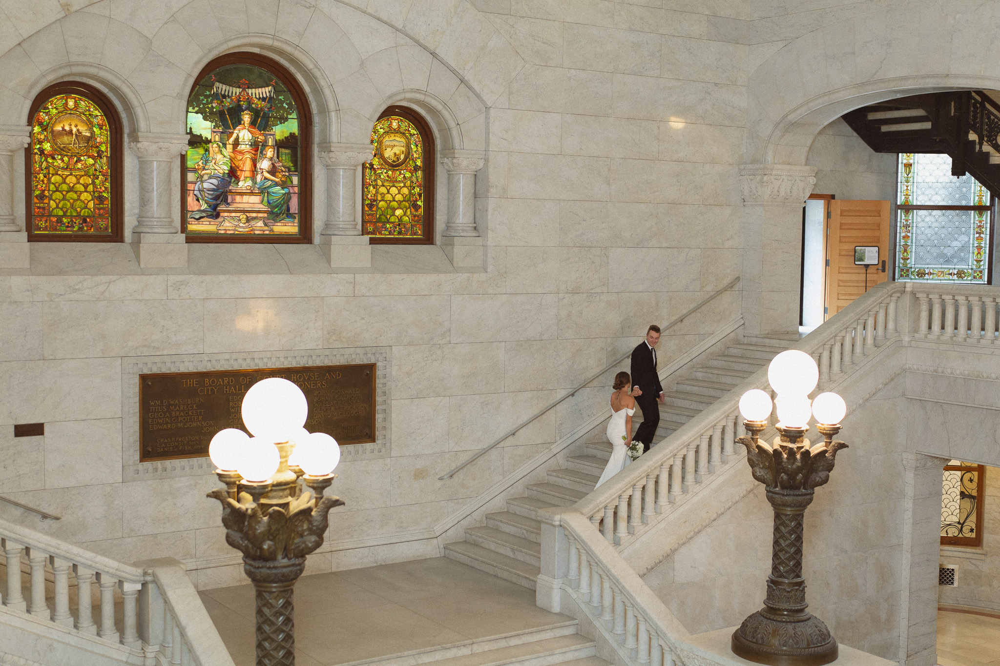 Bride and groom walking up the iconic marble staircase at their Minneapolis City Hall elopement.