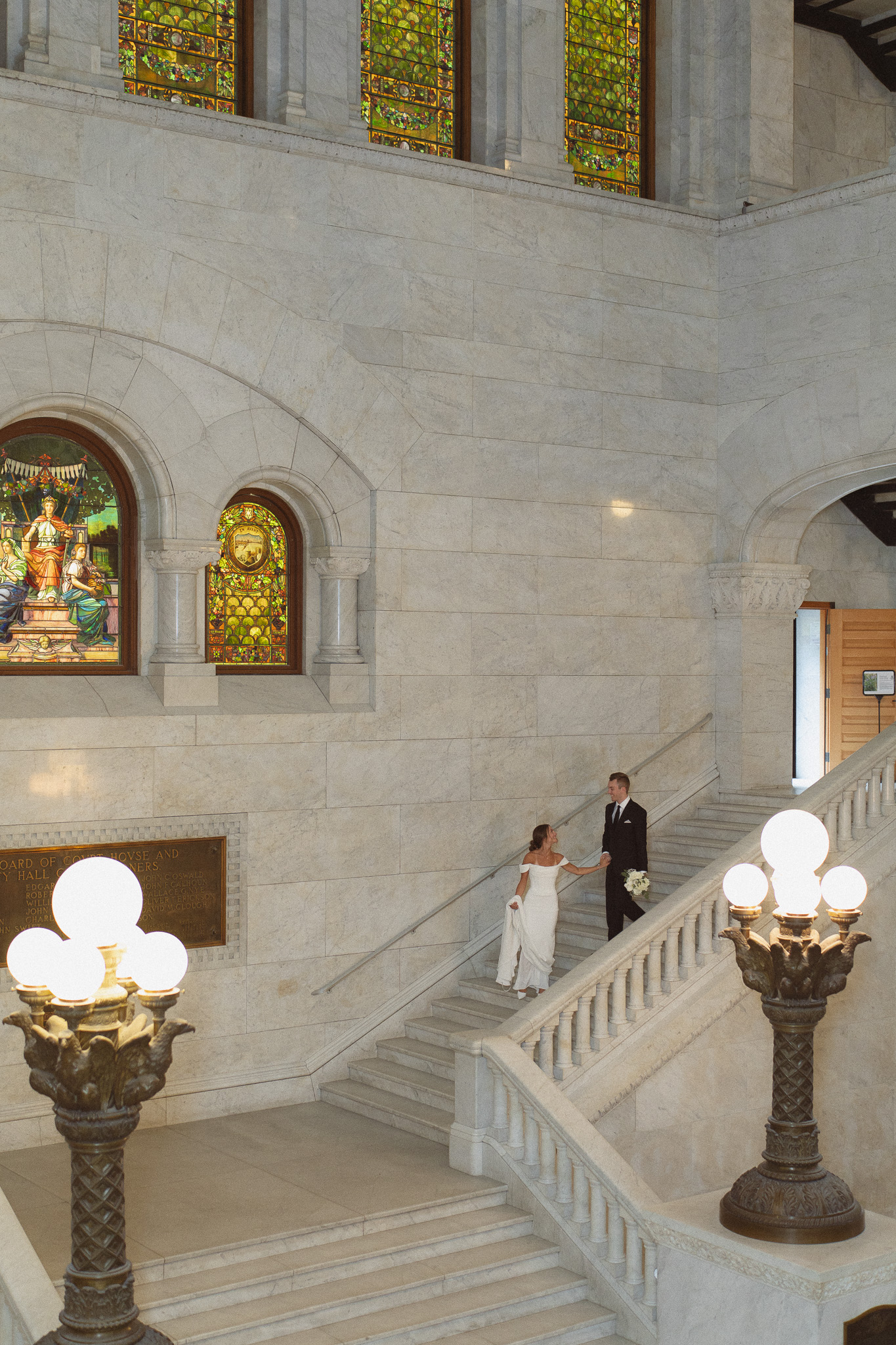 Bride and Groom walking down the beautiful marble staircase inside the Minneapolis City Hall
