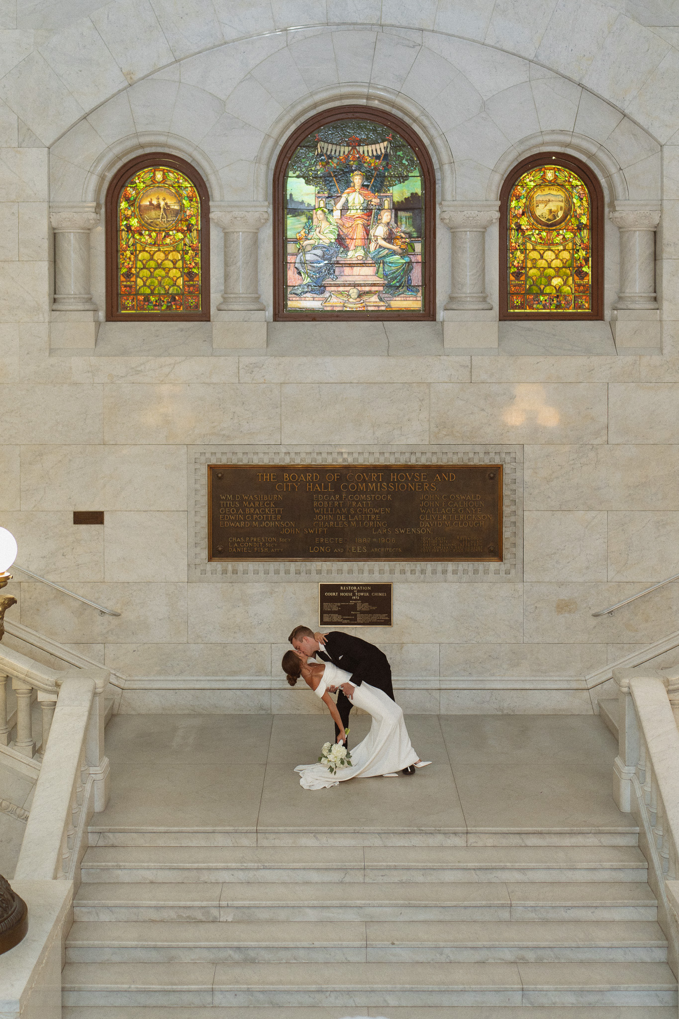 Bride and groom posing on the iconic marble staircase at their Minneapolis City Hall elopement.