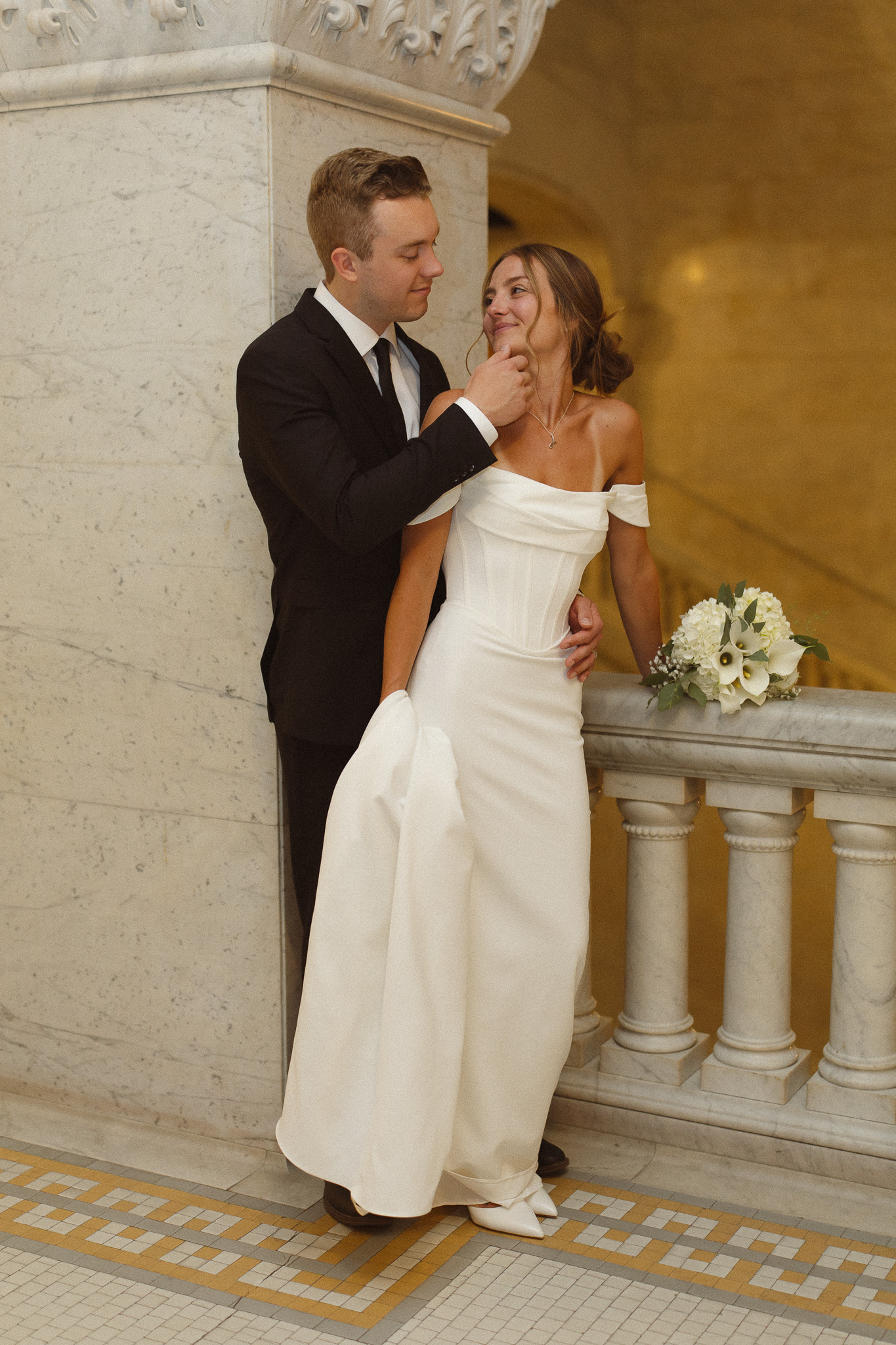 Groom taking bride's chin in closer for a kiss