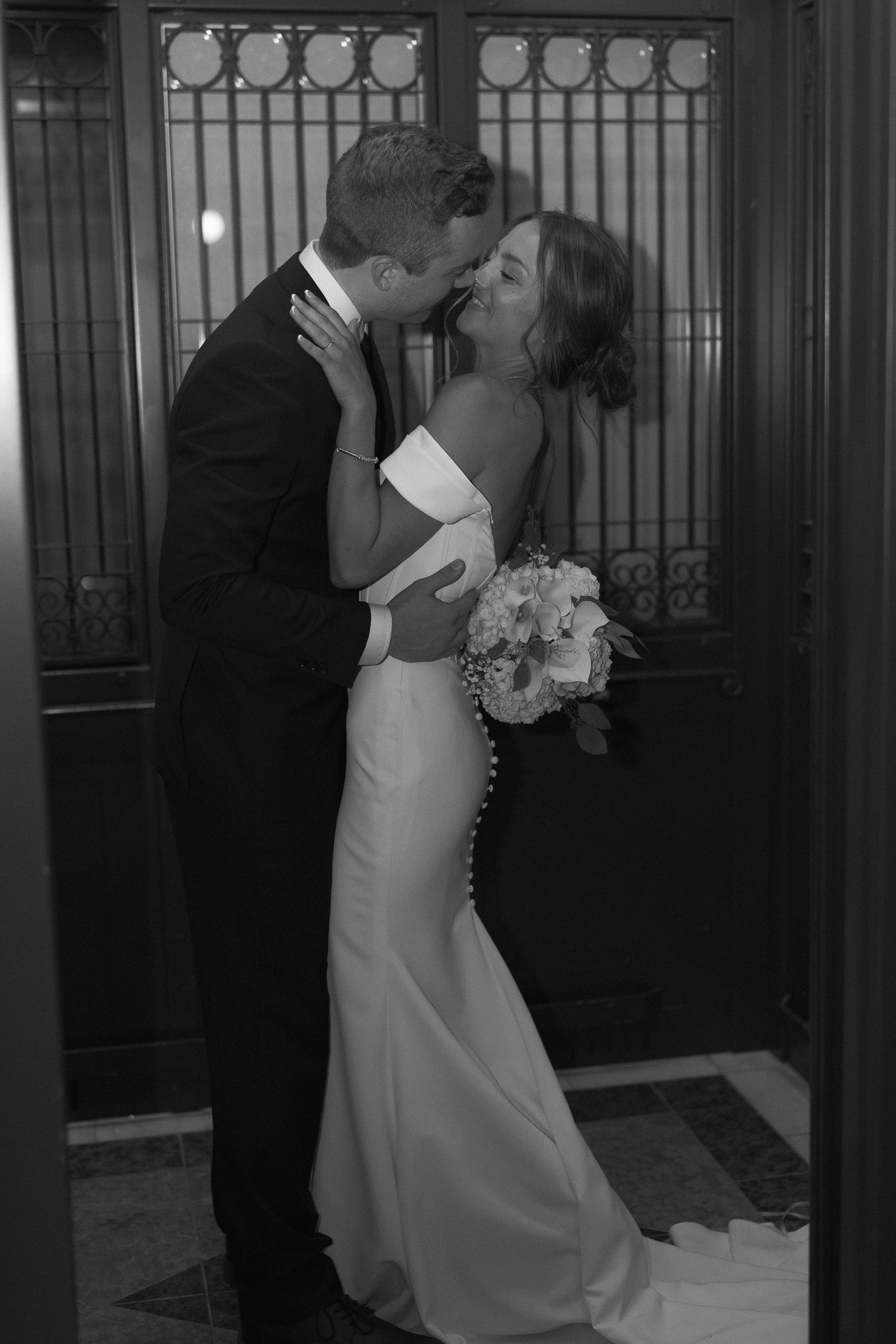 Bride and Groom kissing passionately inside the elevator as the doors close