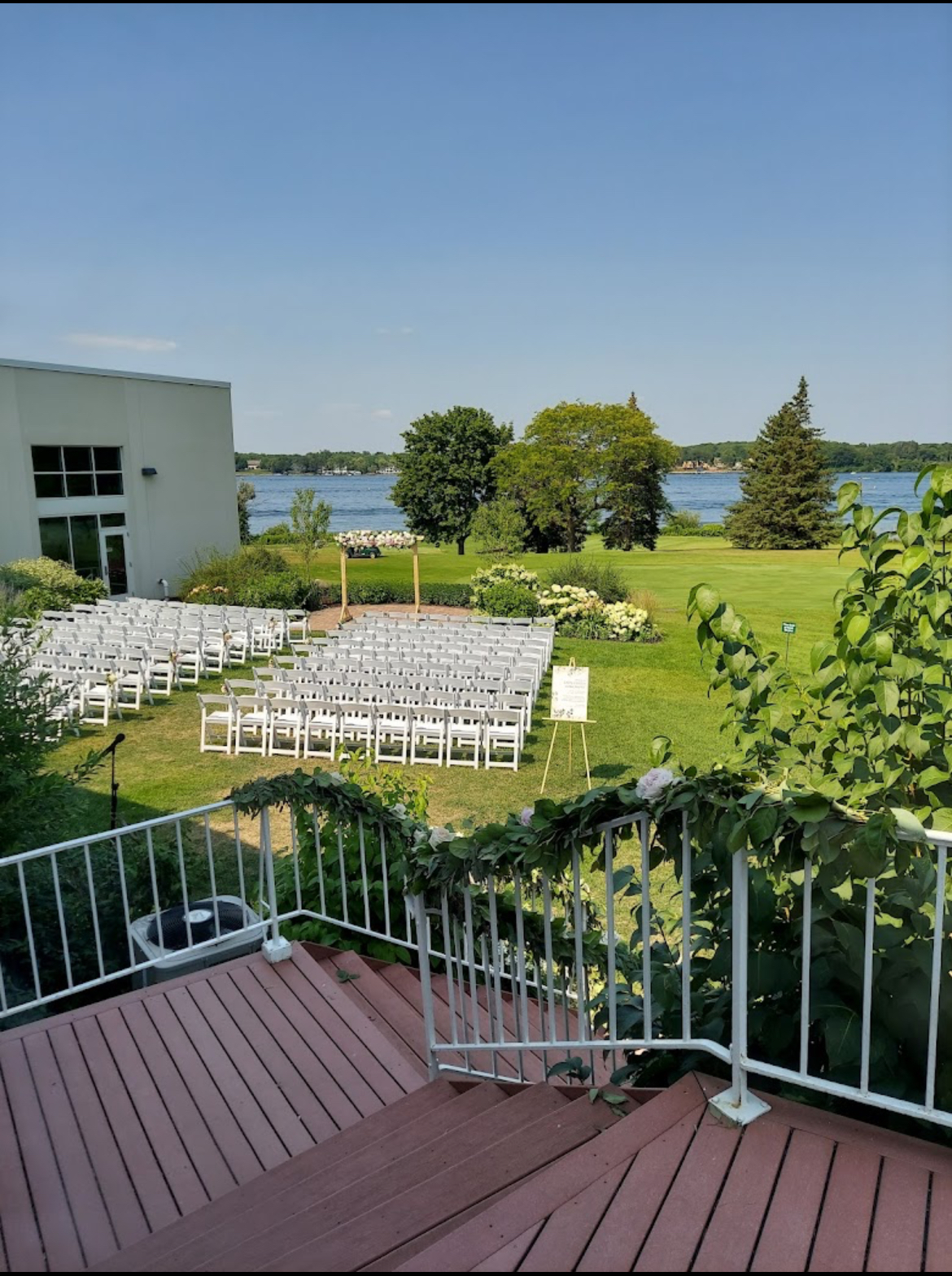 Ceremony setup outside the Lafayette club with white chairs and white and green florals
