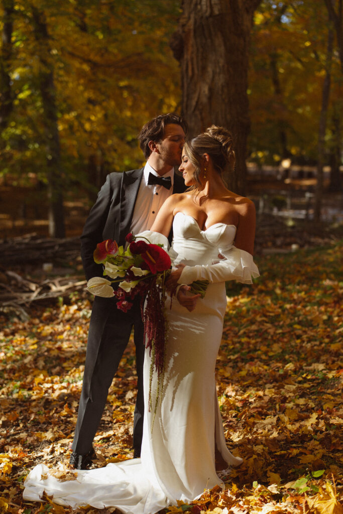 Bride and groom portrait in the warm, autumn sunlight under the fall trees near Lake Minnetonka