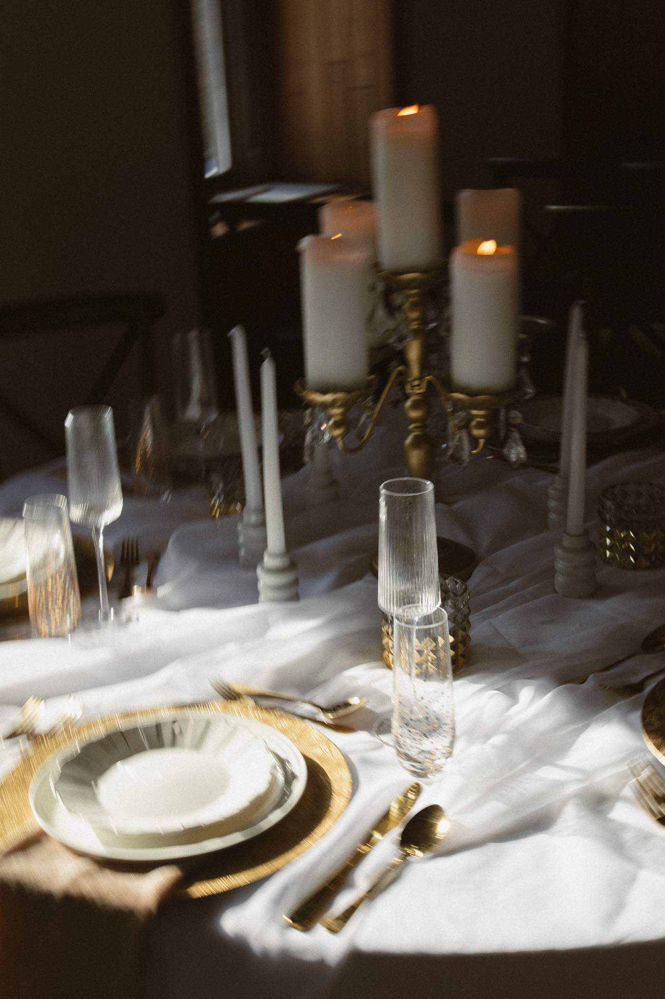 Romantic editorial wedding reception table with lots of gold, creams and candles at The Hutton House