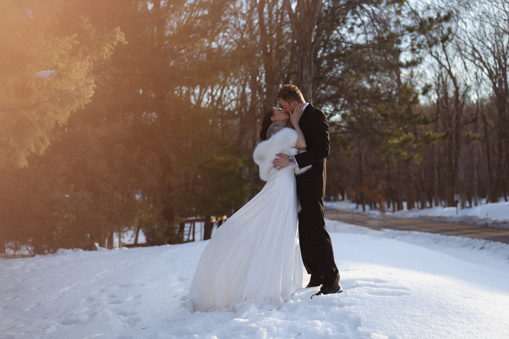 Groom and Bride kissing in the snow during their wedding day at The Hutton House in Minnesota