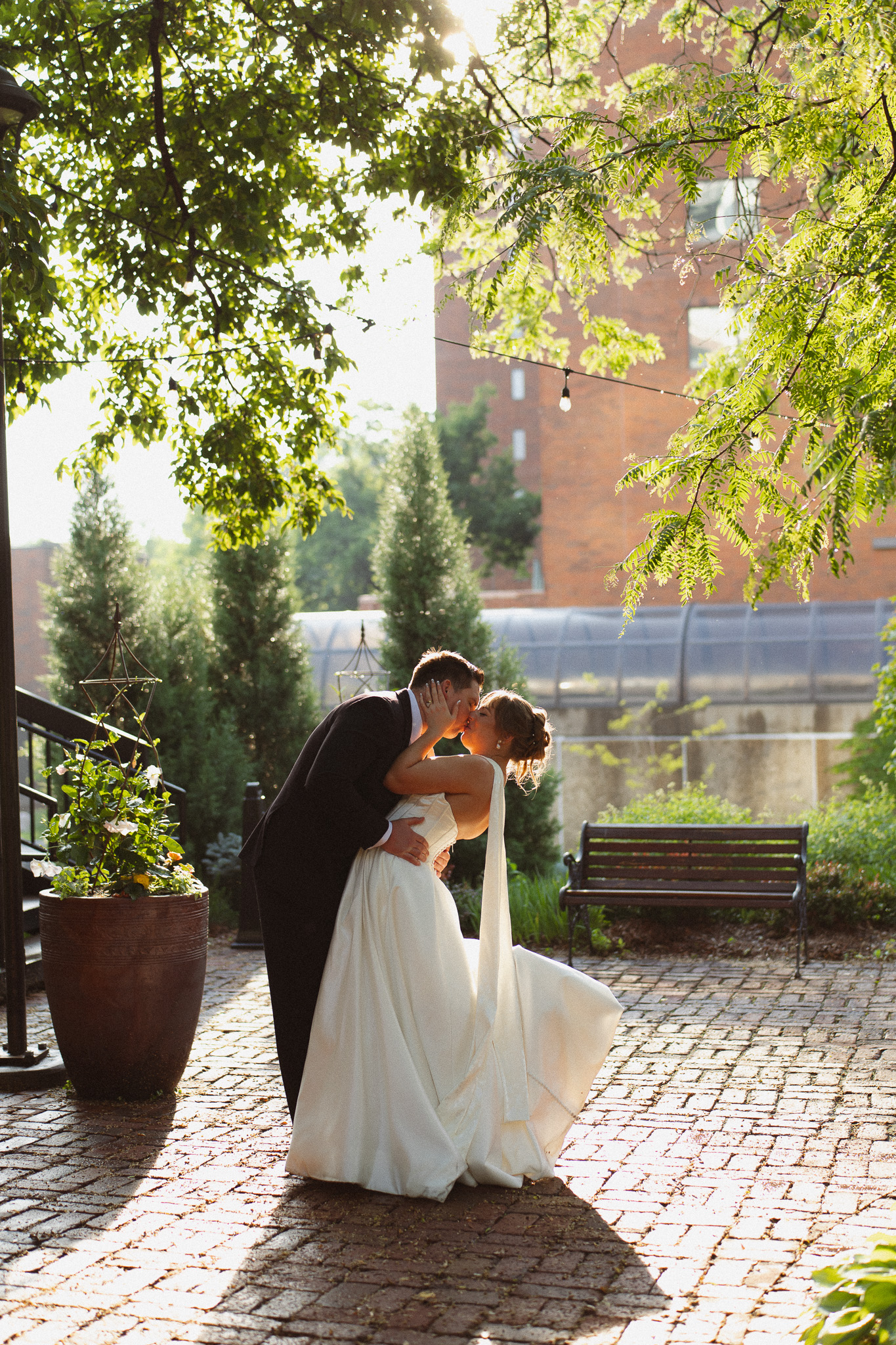 Bride and groom dip kissing during a nature-inspired wedding at the Woodlands Glasshaus