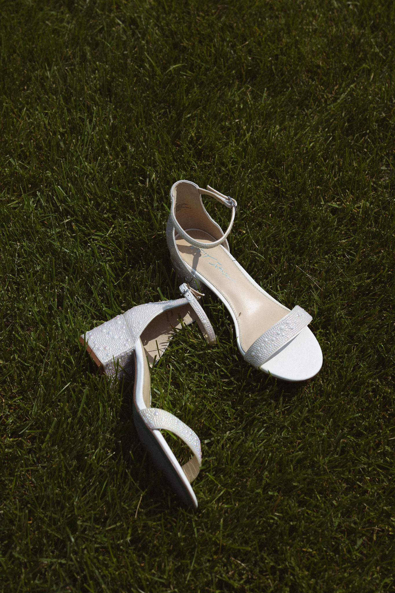 Stunning editorial bridal shoe shot laying on the grass