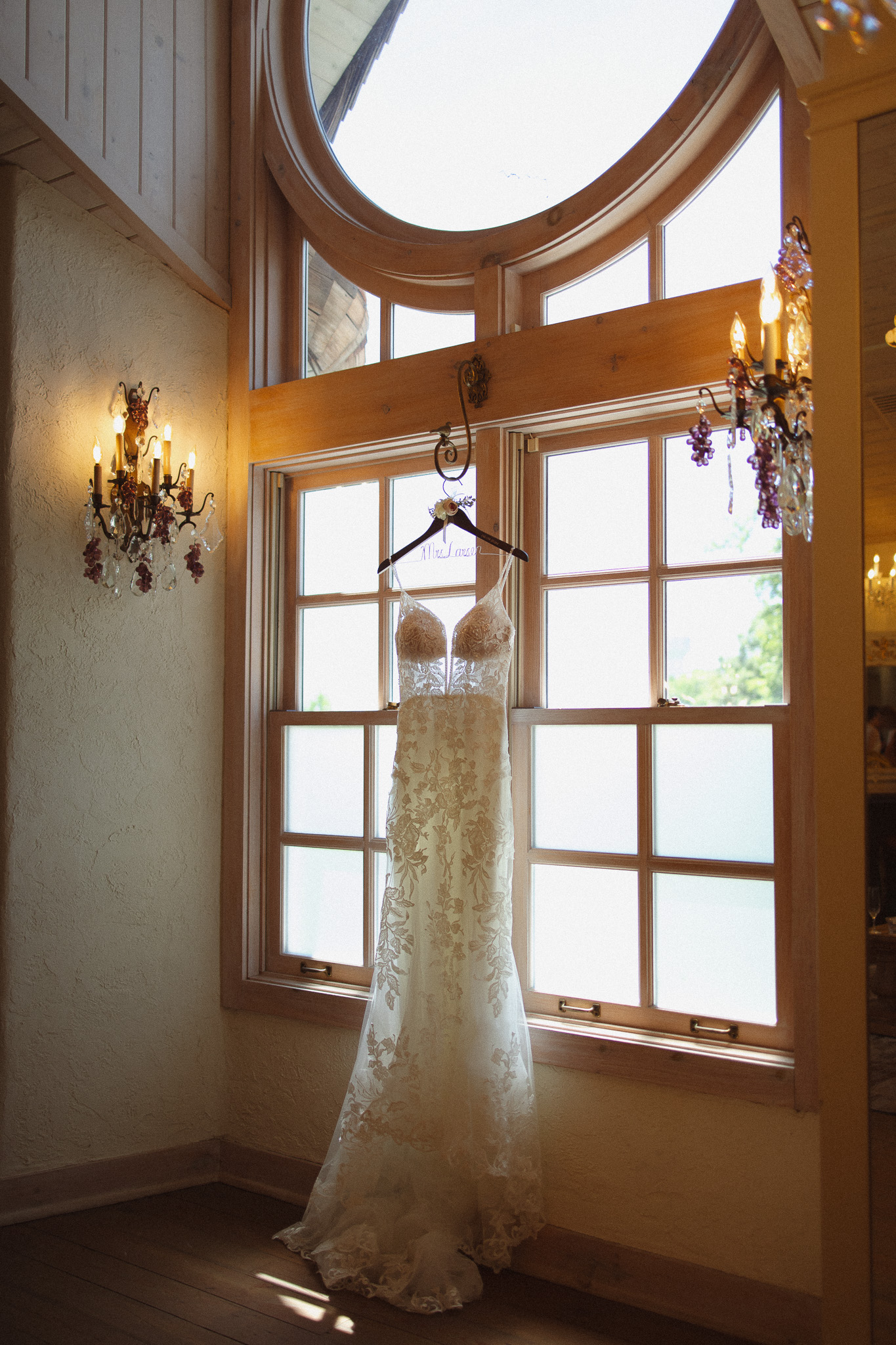 Stunning natural light shot of a wedding dress hanging by the window in the bridal suite at The Edward Anne Estate at Bavaria Downs