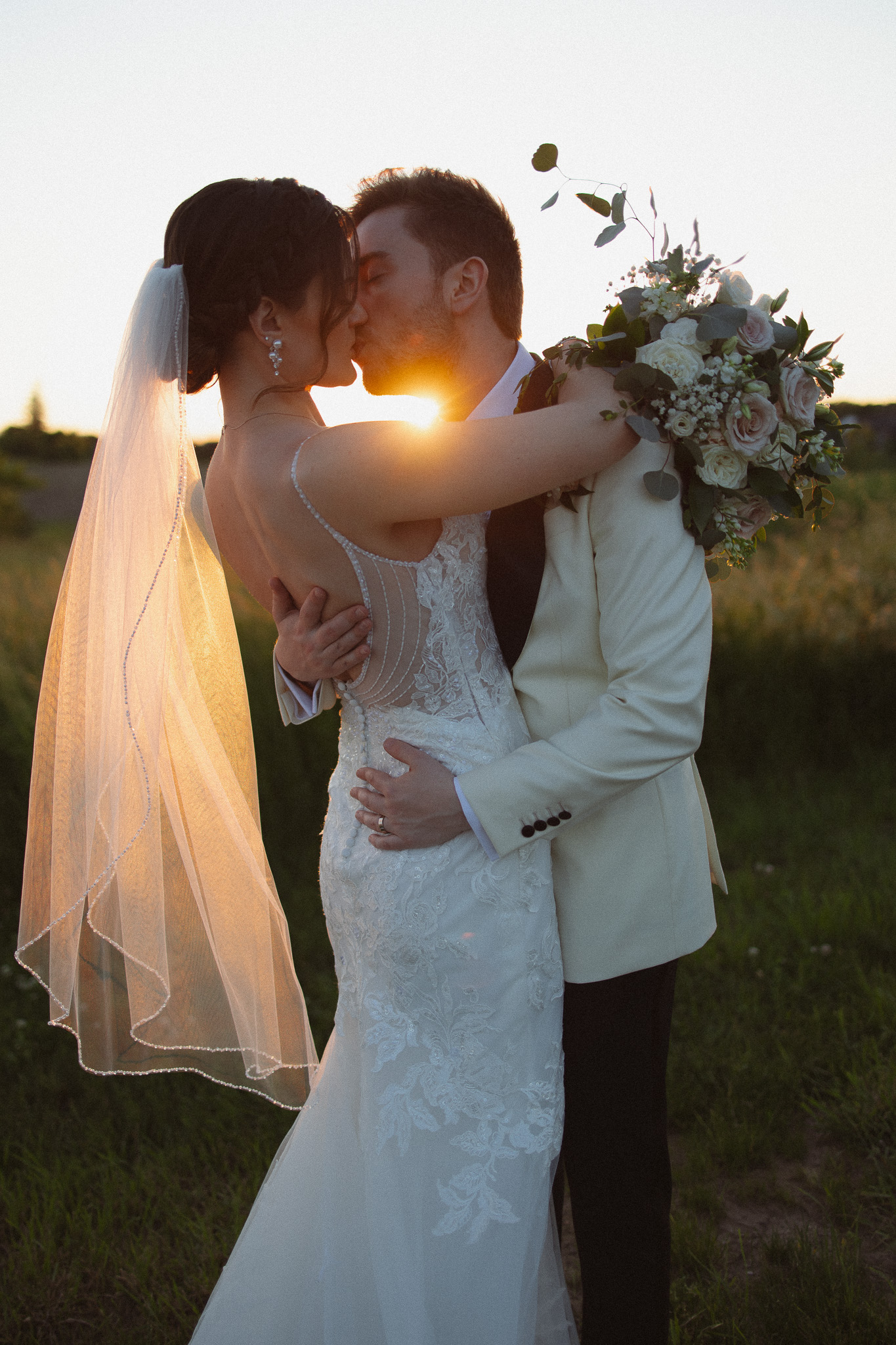 Stunning sunset portrait of bride and groom kissing at Edward Anne, Bavaria Downs