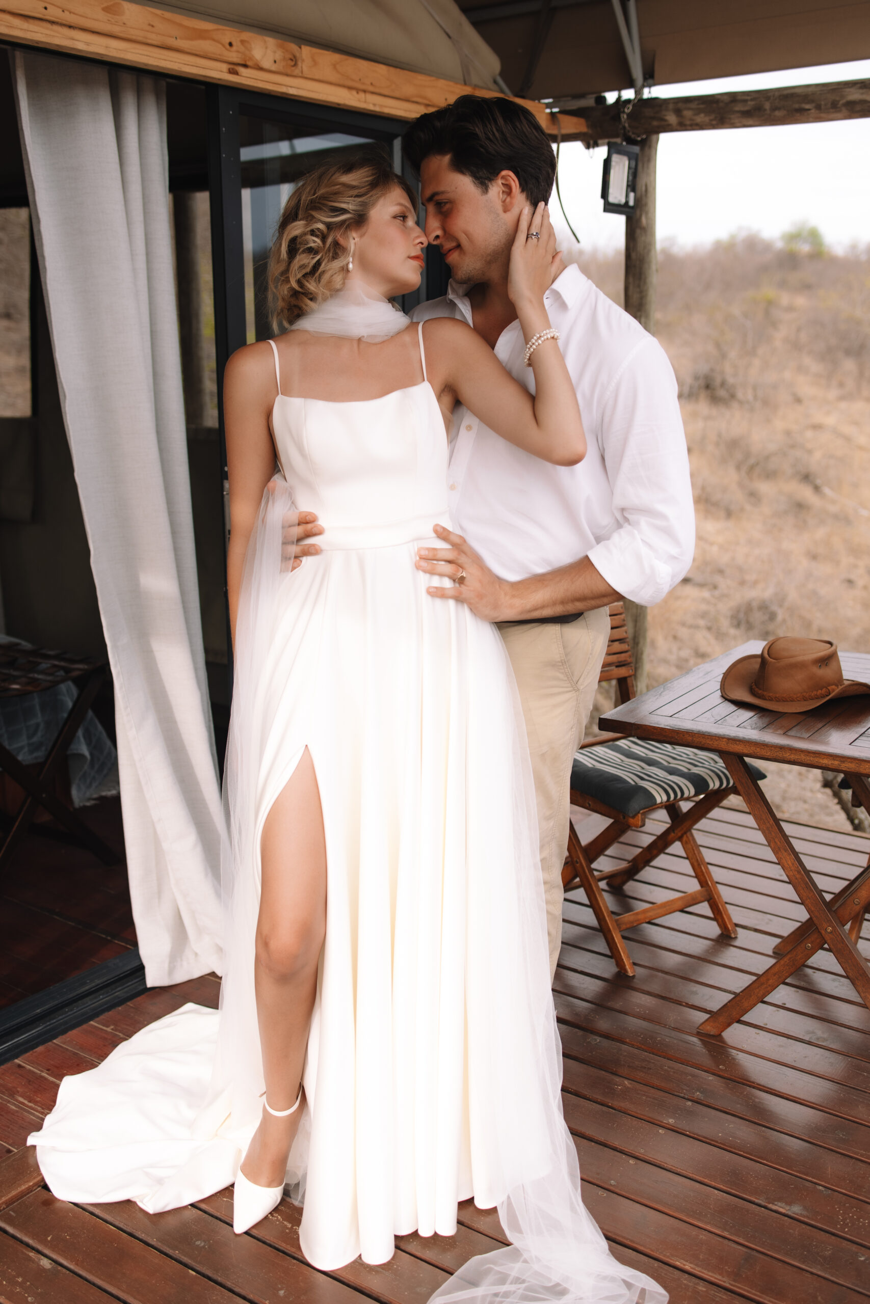 Bride and groom embracing on the deck of a safari tent lodge during an intimate elopement