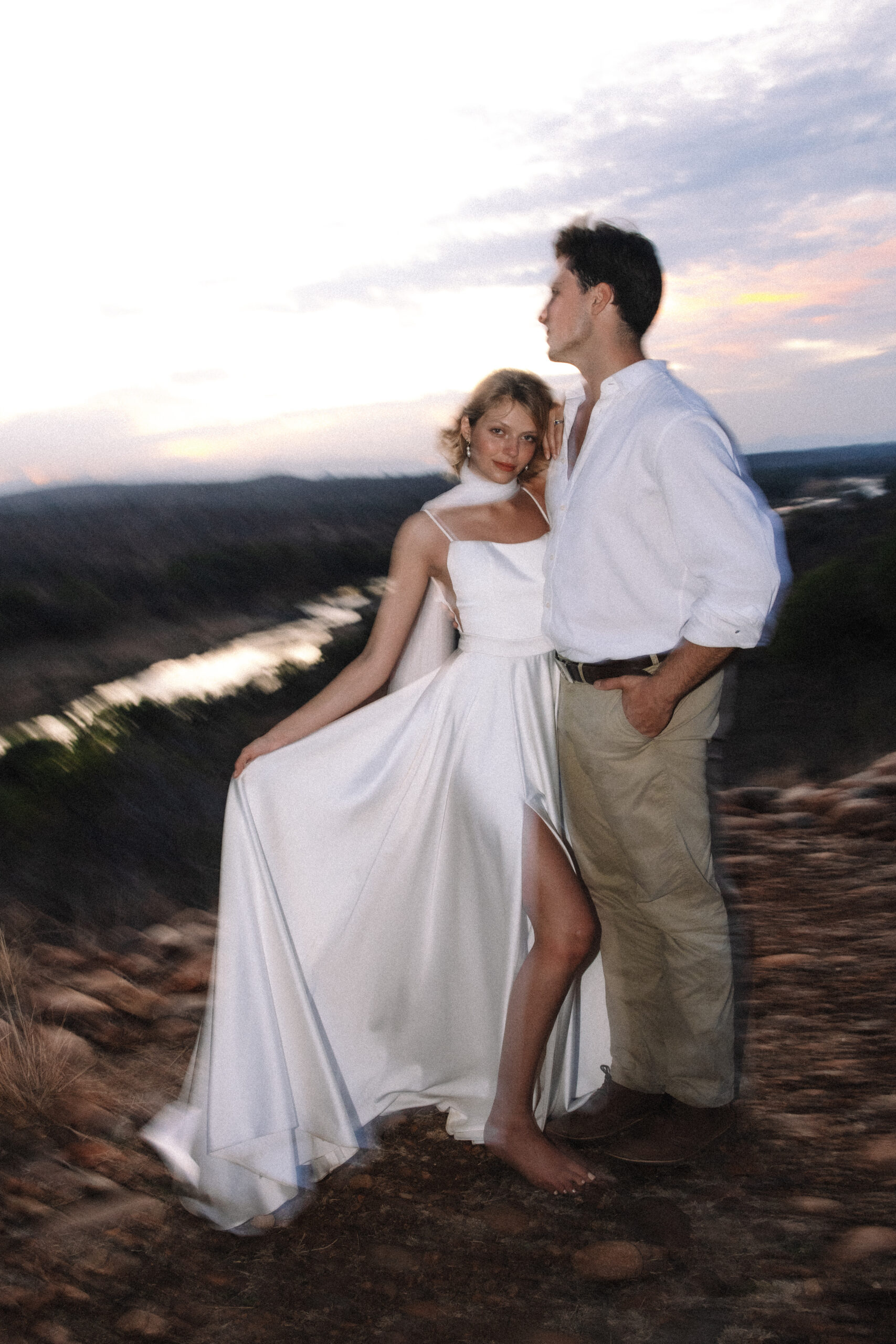 Bride and groom posing on a cliff overlooking the landscape during a luxury South Africa safari