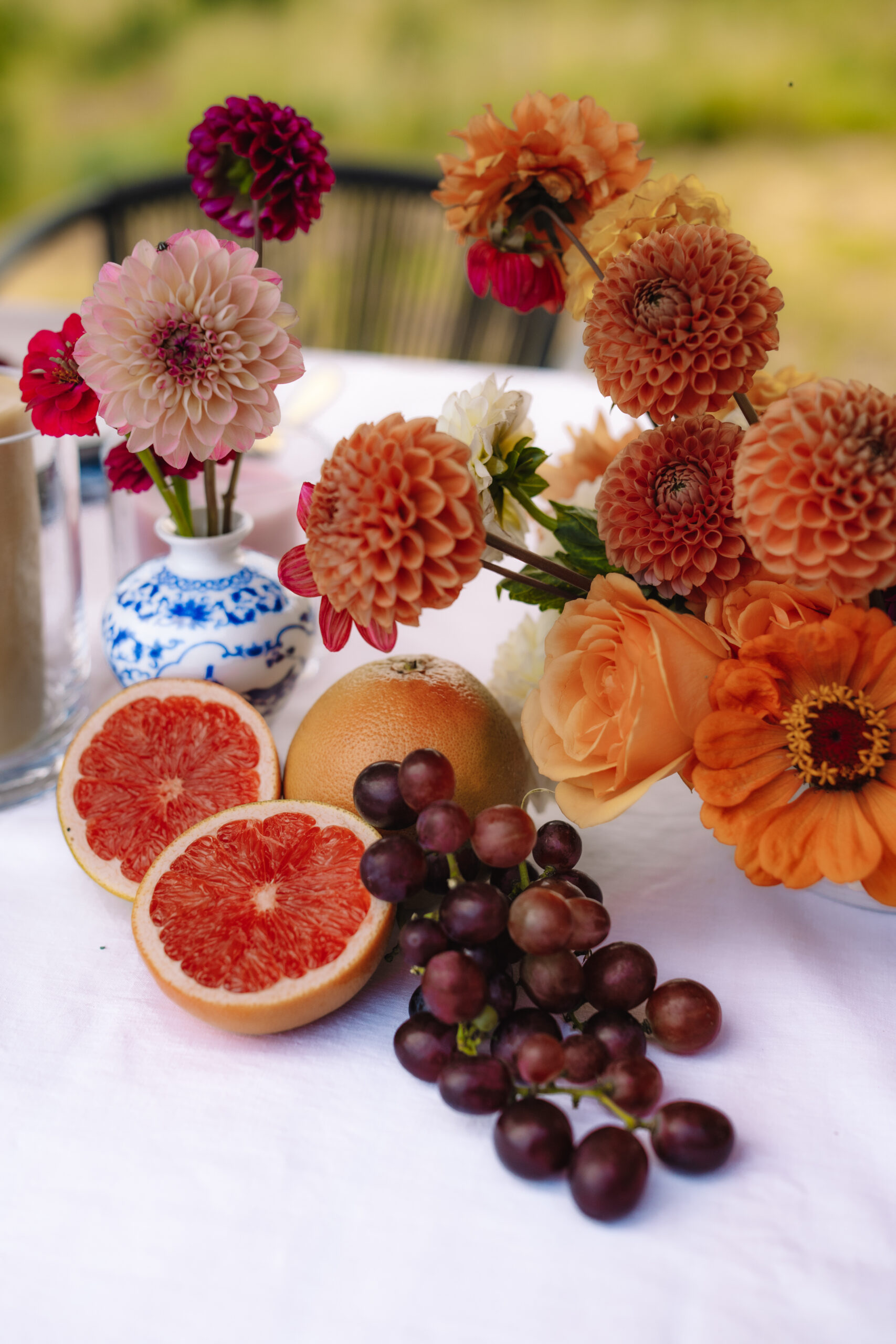 Colorful floral centerpiece with fruit and grapes styled for an outdoor safari table