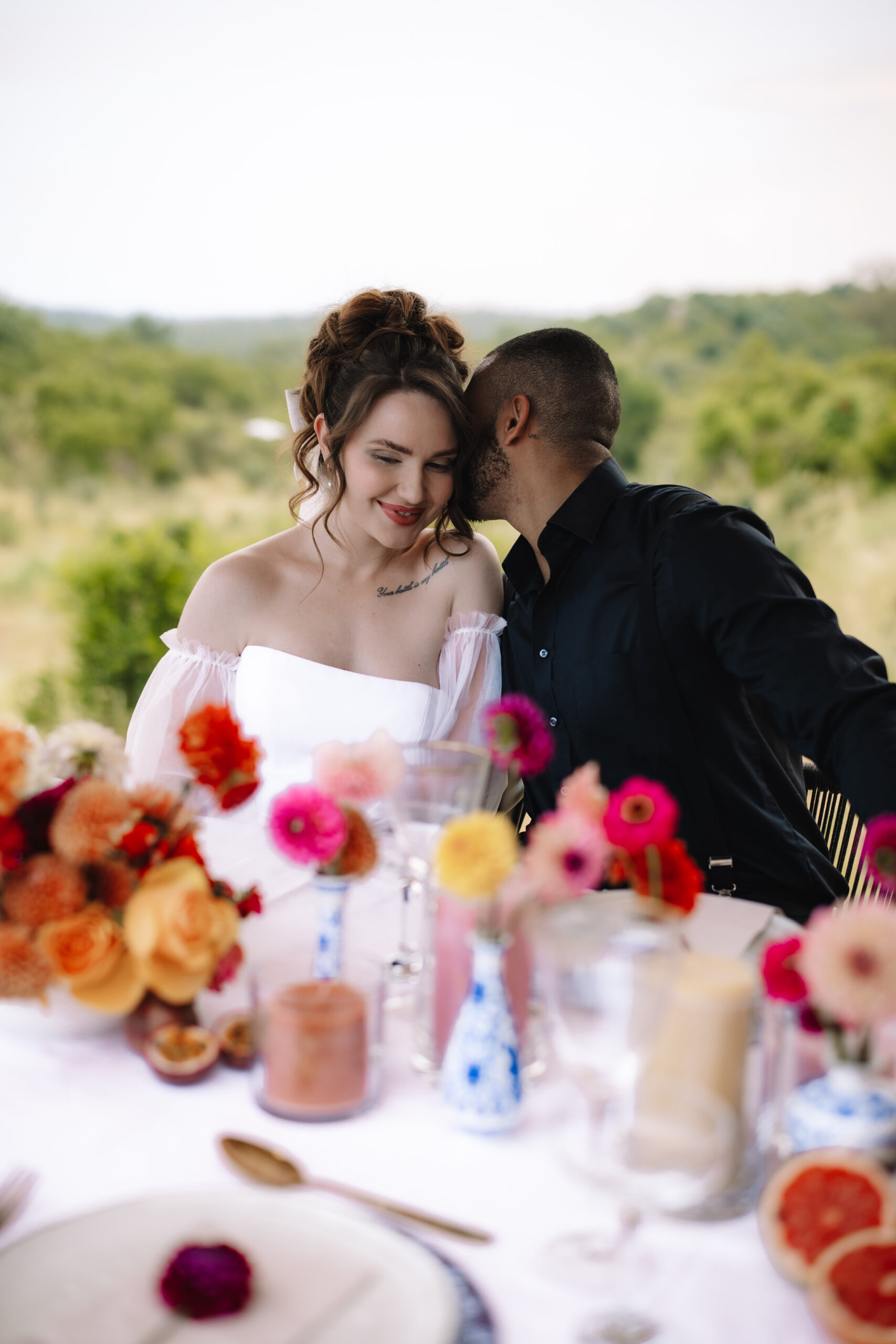 Bride and groom sharing an intimate moment at a styled table during a luxury South Africa safari wedding