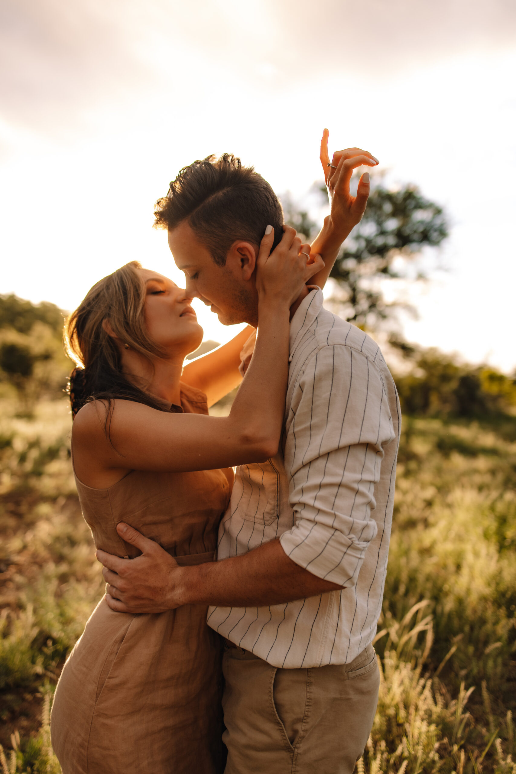 Couple embracing in tall grass at golden hour during an intimate safari elopement