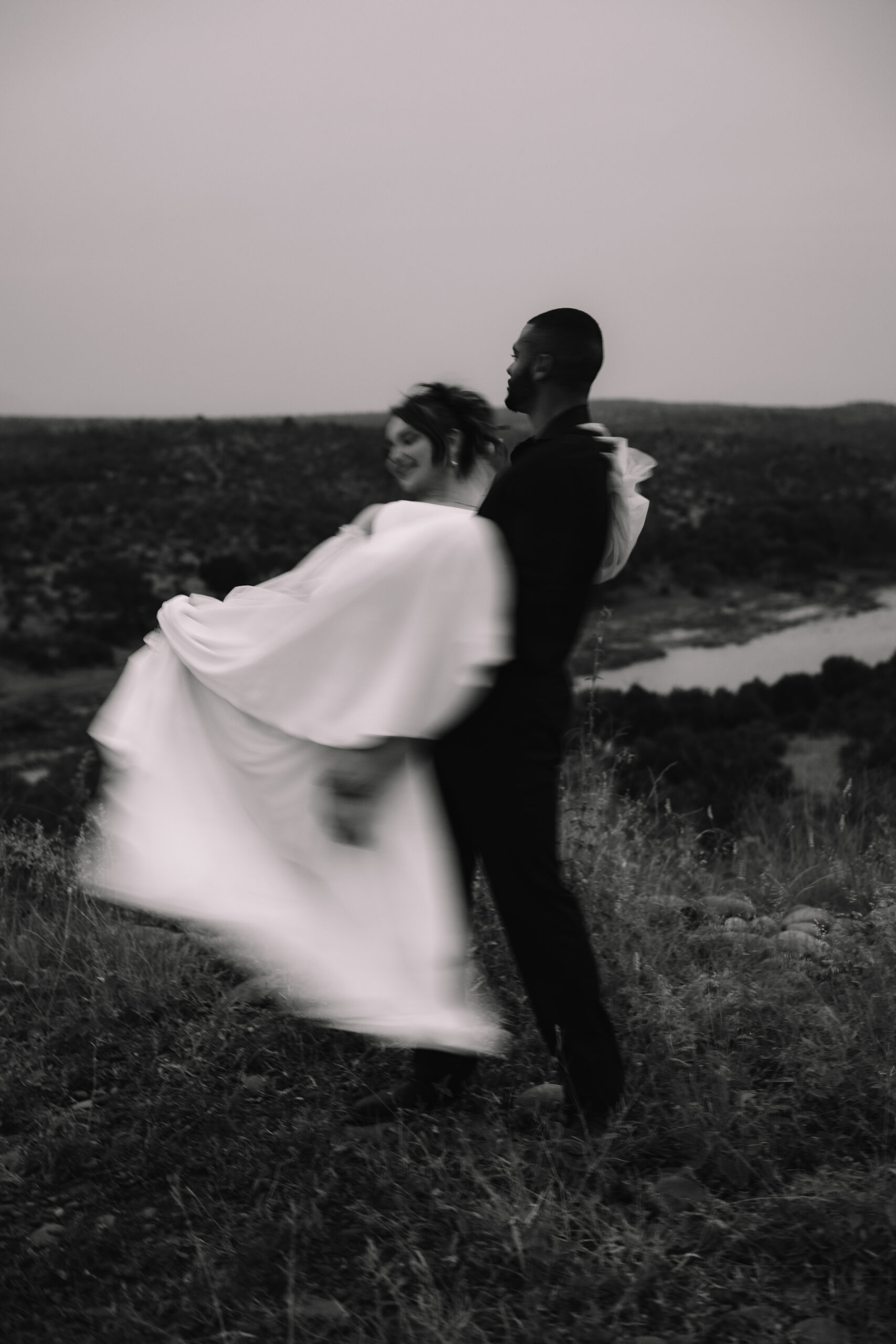 Blurry photo of groom swinging bride around after safari elopement in south africa