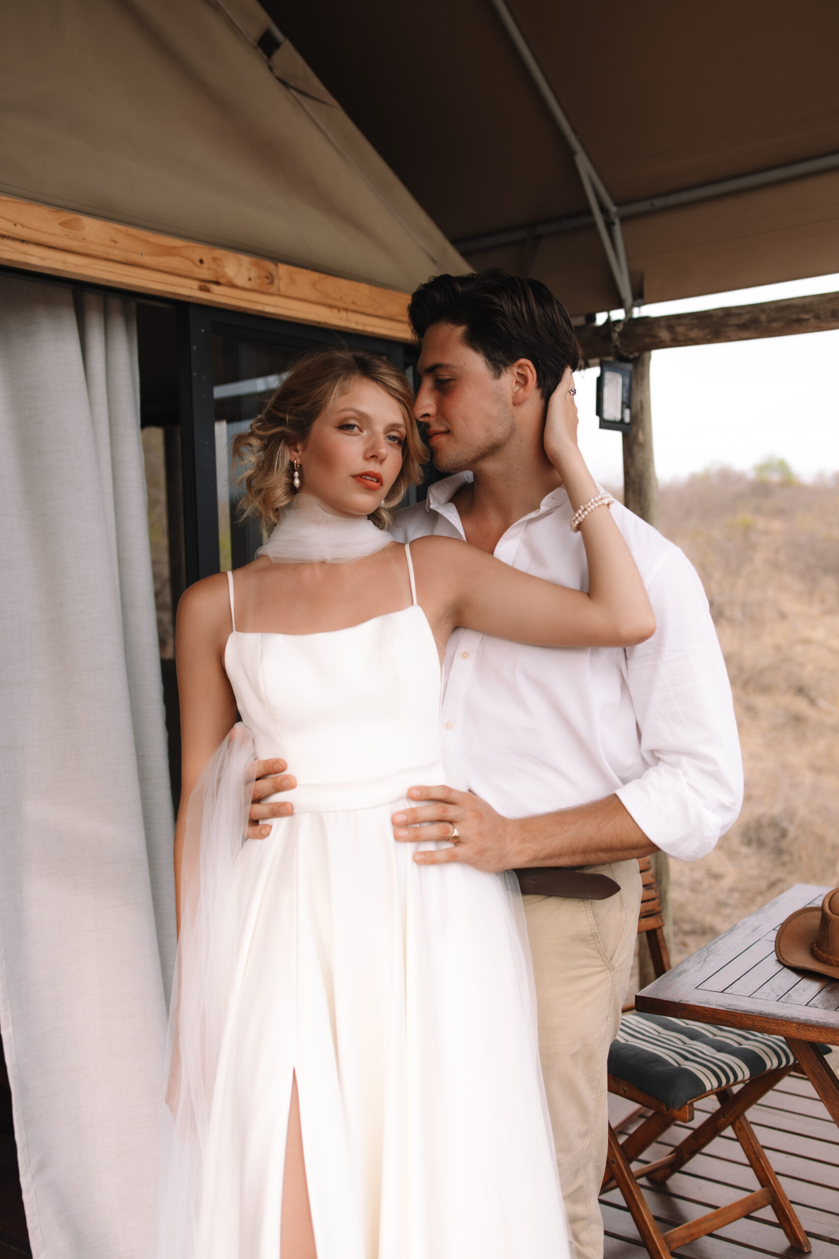 Bride and groom standing together outside a luxury safari tent during their safari elopement in South Africa