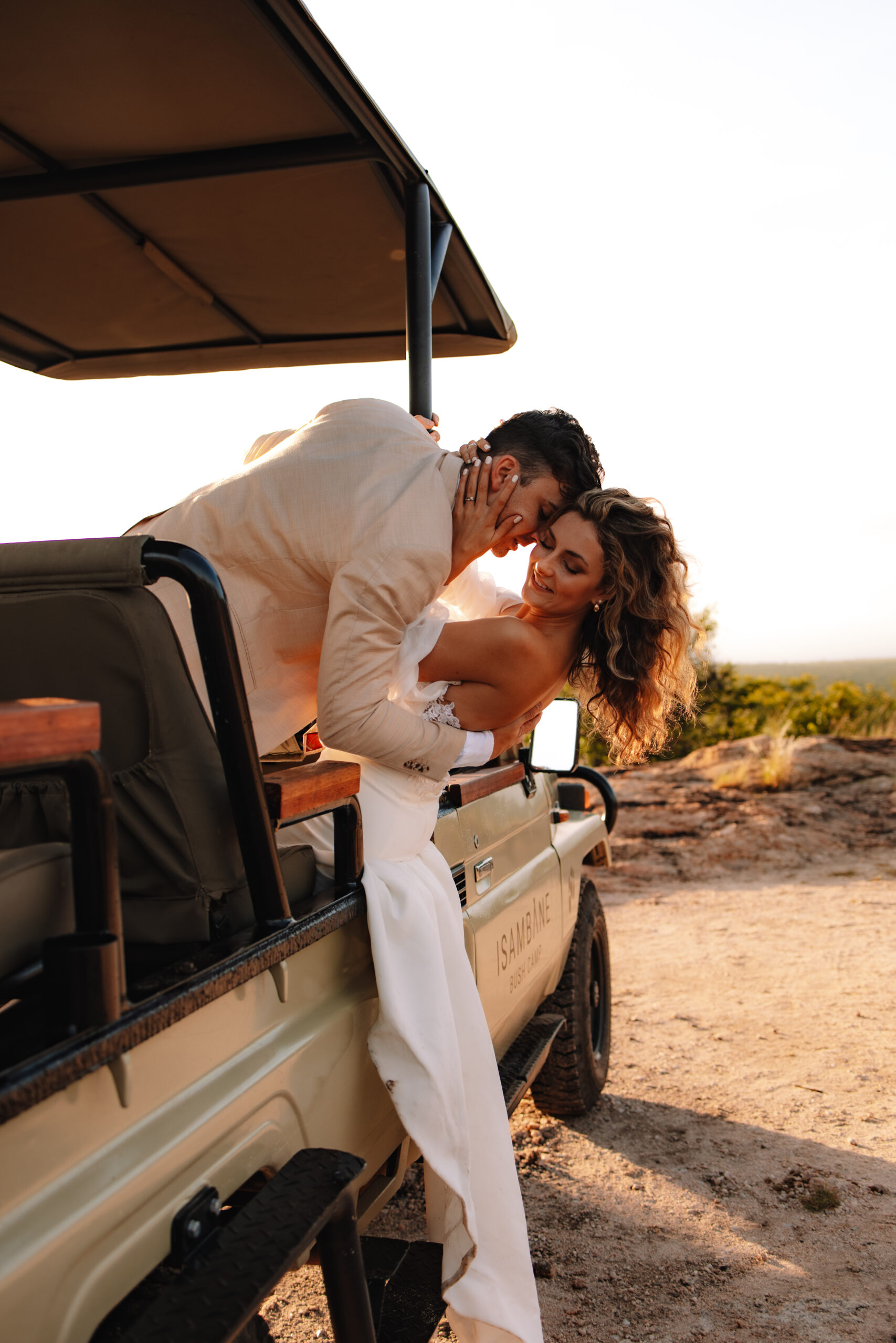 Bride and groom sharing a quiet moment beside a safari vehicle during their safari elopement in South Africa