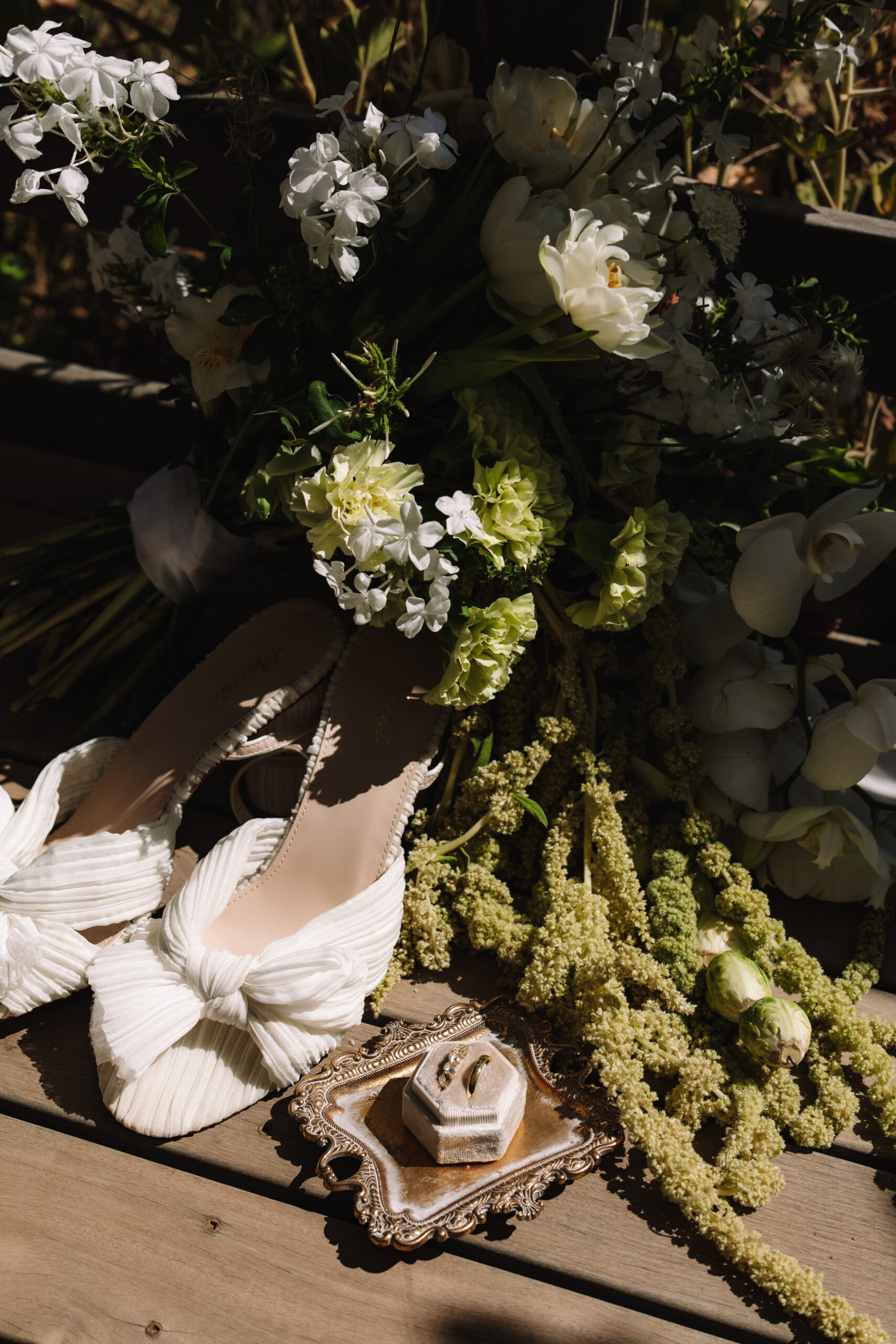 Wedding detail flat lay with ivory heels, bouquet, and ring styled for cape town wedding locations.