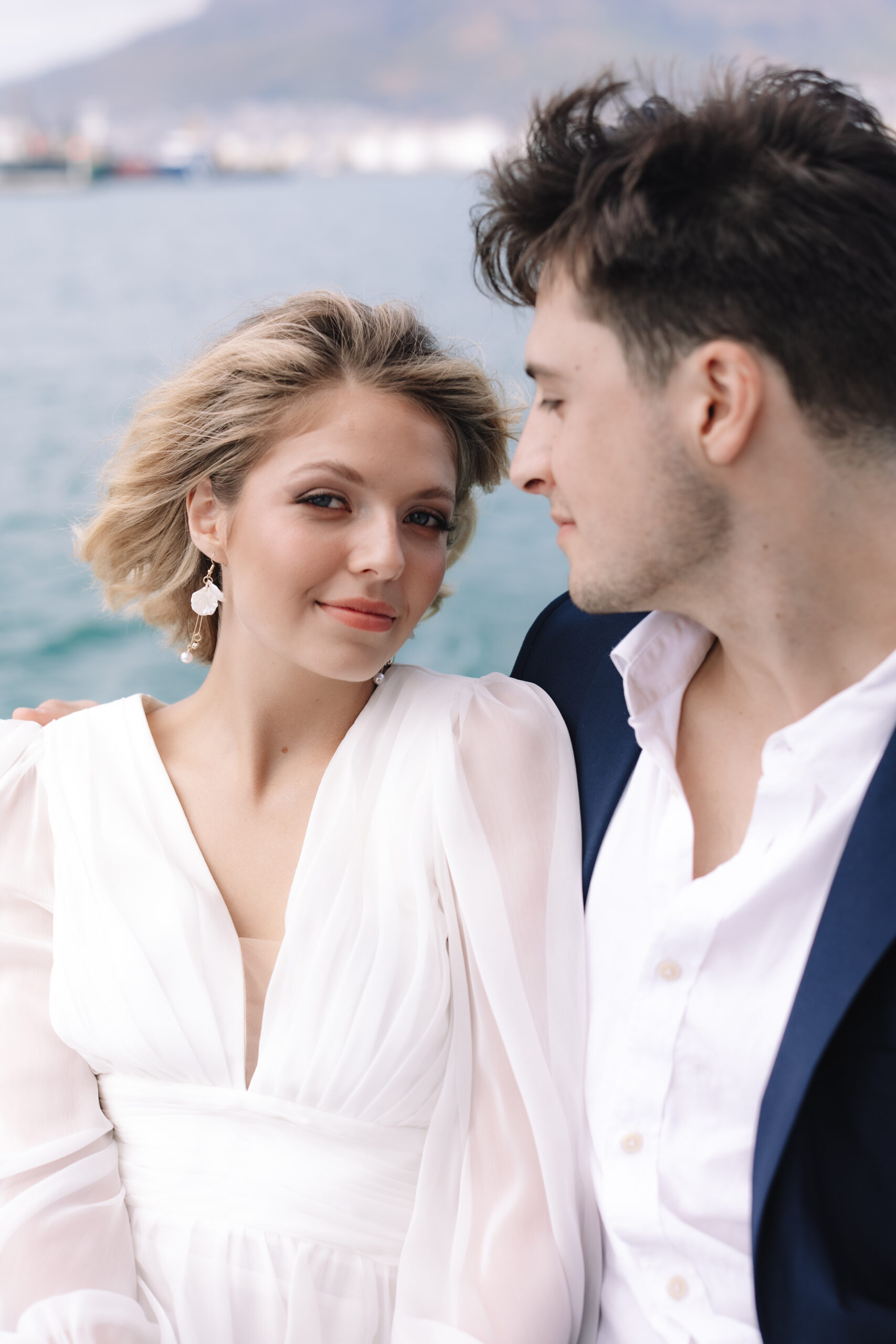 Close-up portrait of bride and groom seated by the ocean in Cape Town.