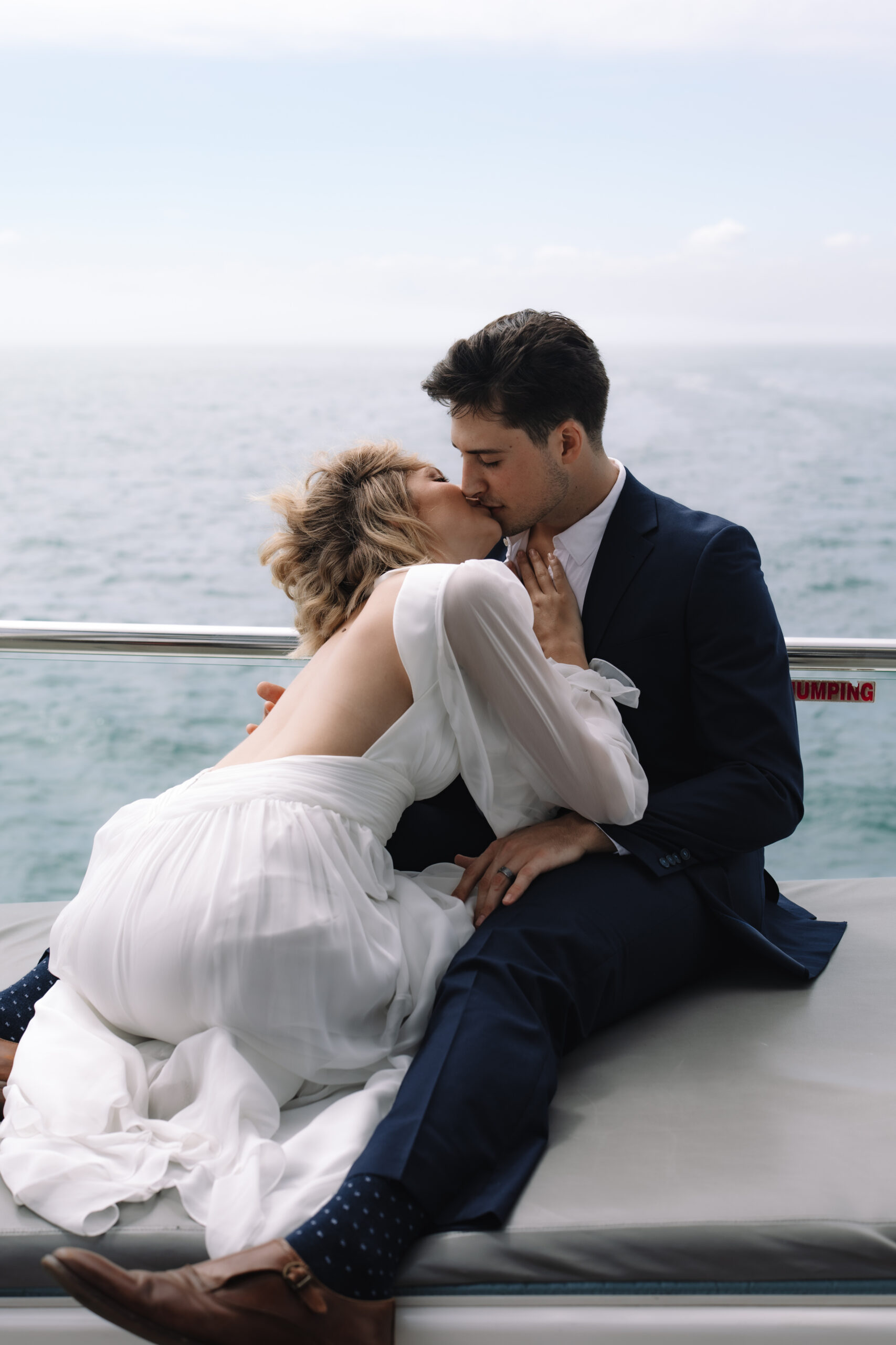 Couple kissing on yacht deck surrounded by open ocean at cape town wedding locations.