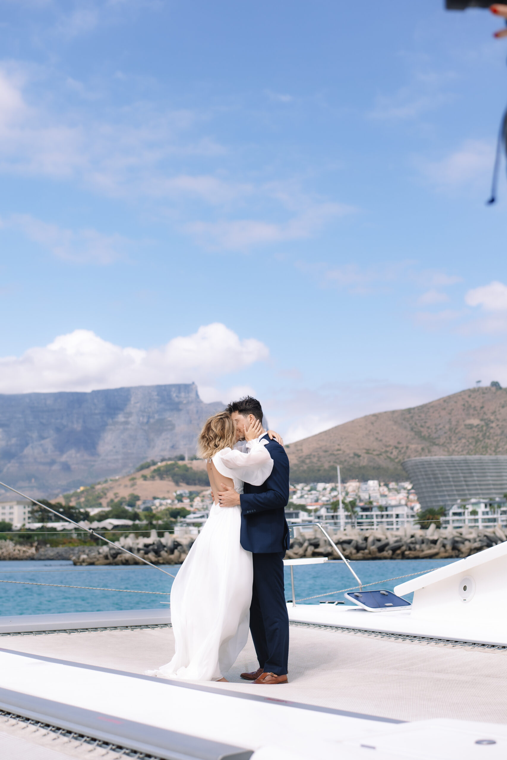 Intimate elopement portrait on a yacht with Table Mountain in the distance.