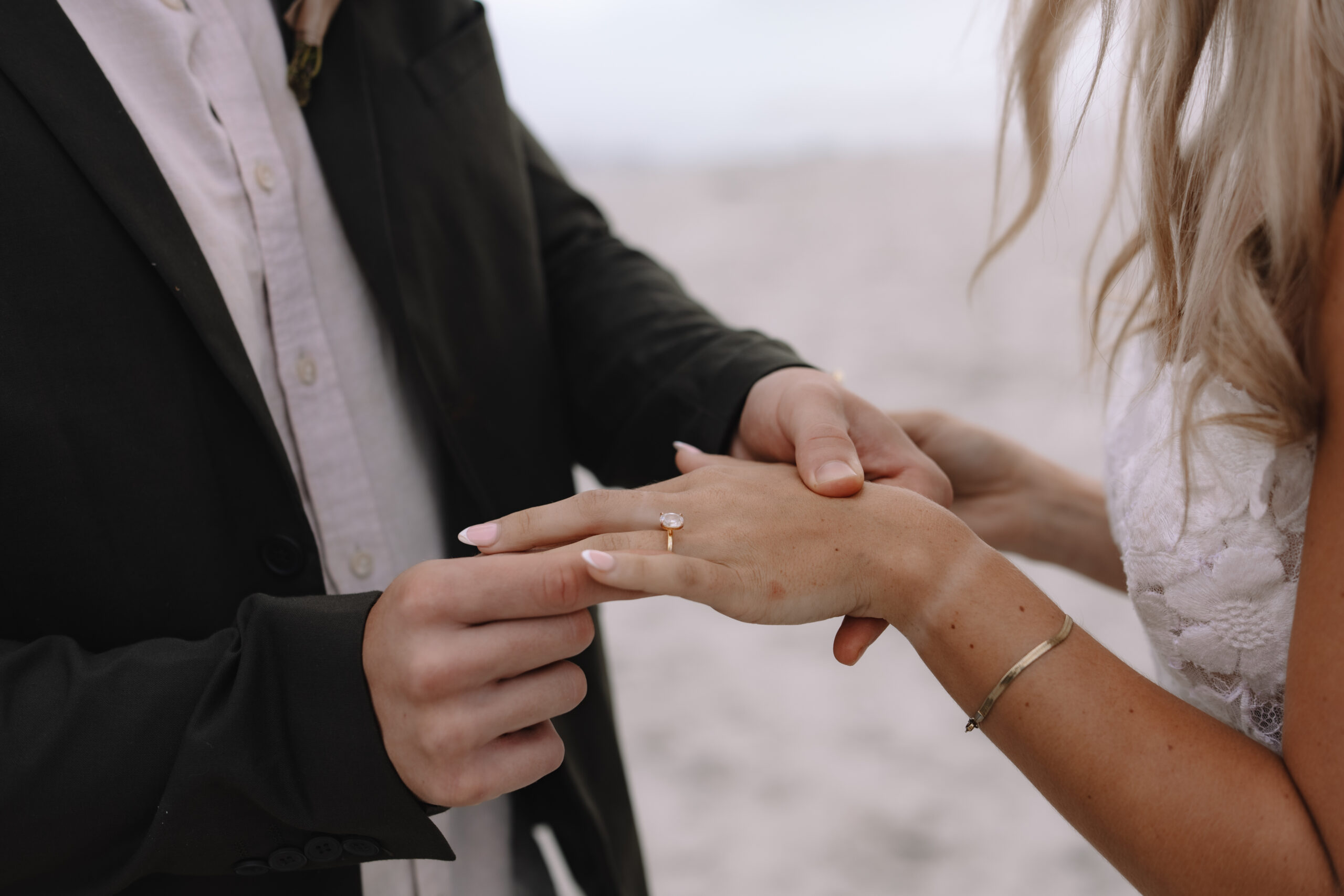 Close-up of ring exchange during intimate beach ceremony at cape town wedding locations.