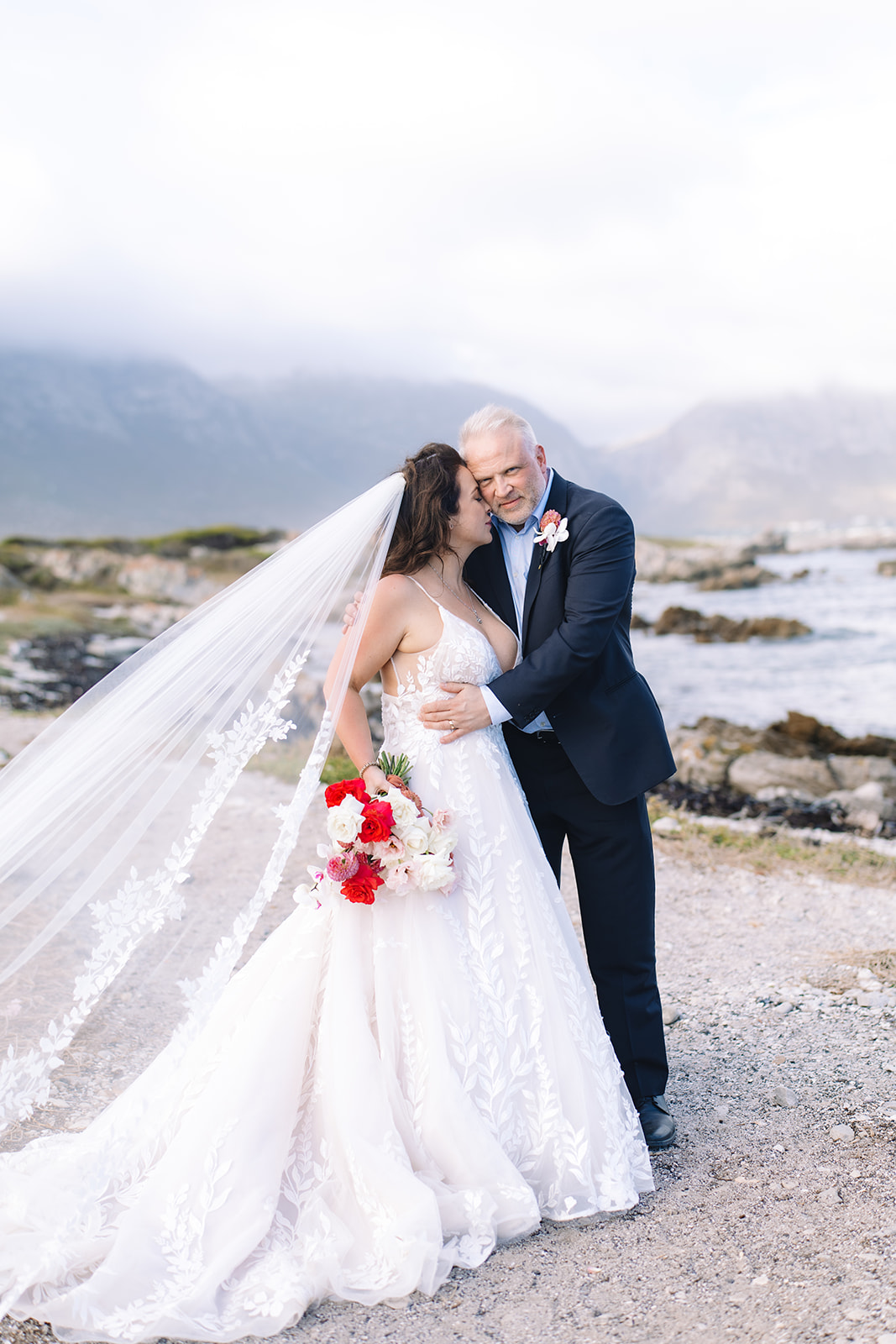 Groom hugs bride as she snuggles into his cheek during romantic elopement in South Africa.