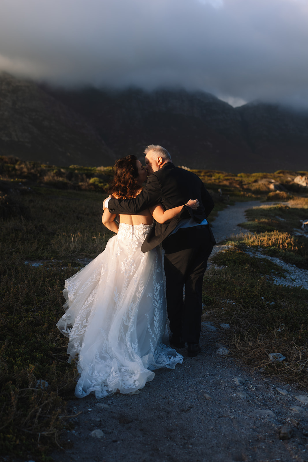 Bride and groom walking through coastal fynbos after their Cape Town elopement
