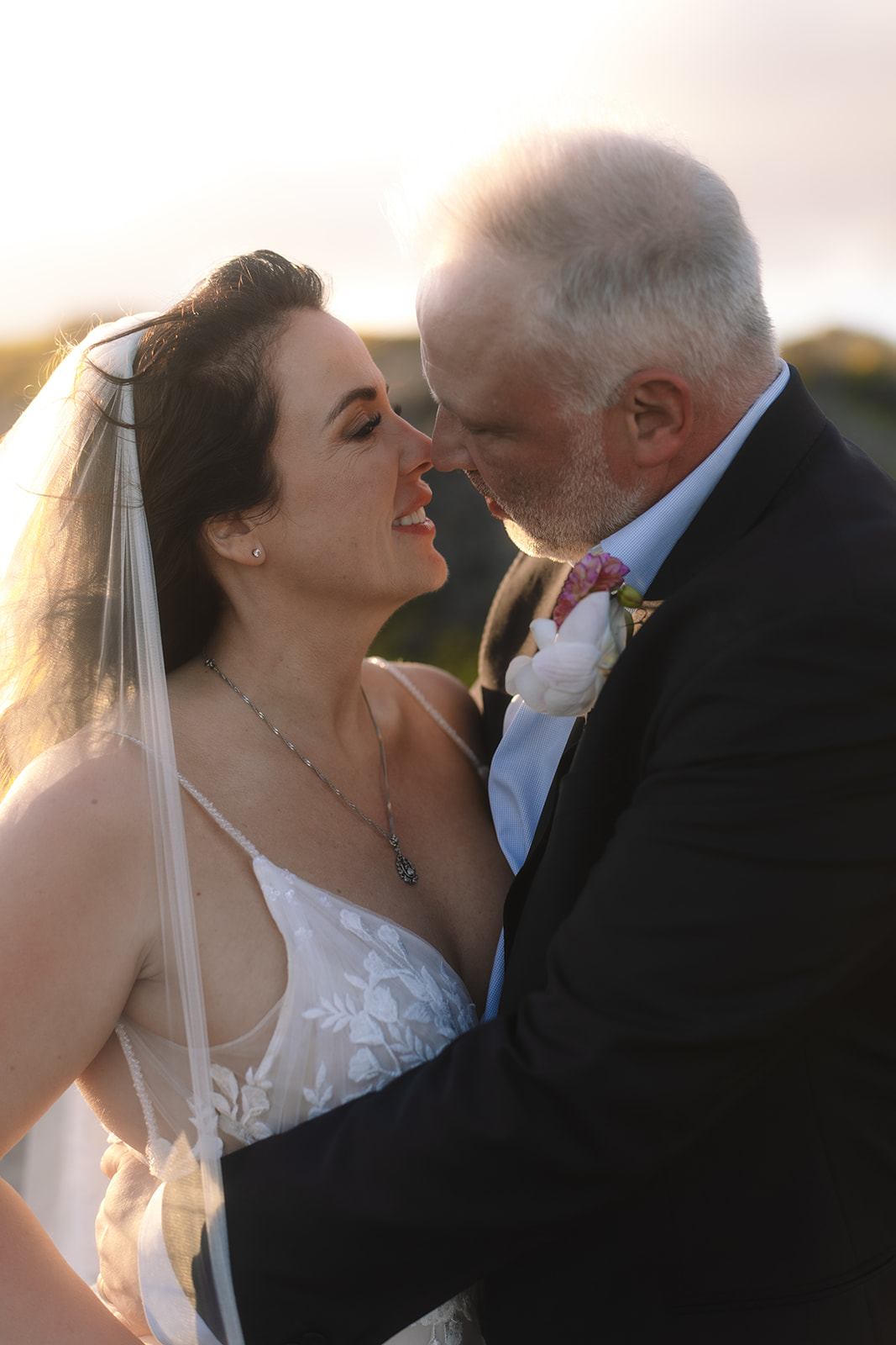Close up of newly married couple kissing as groom brings bride in close.