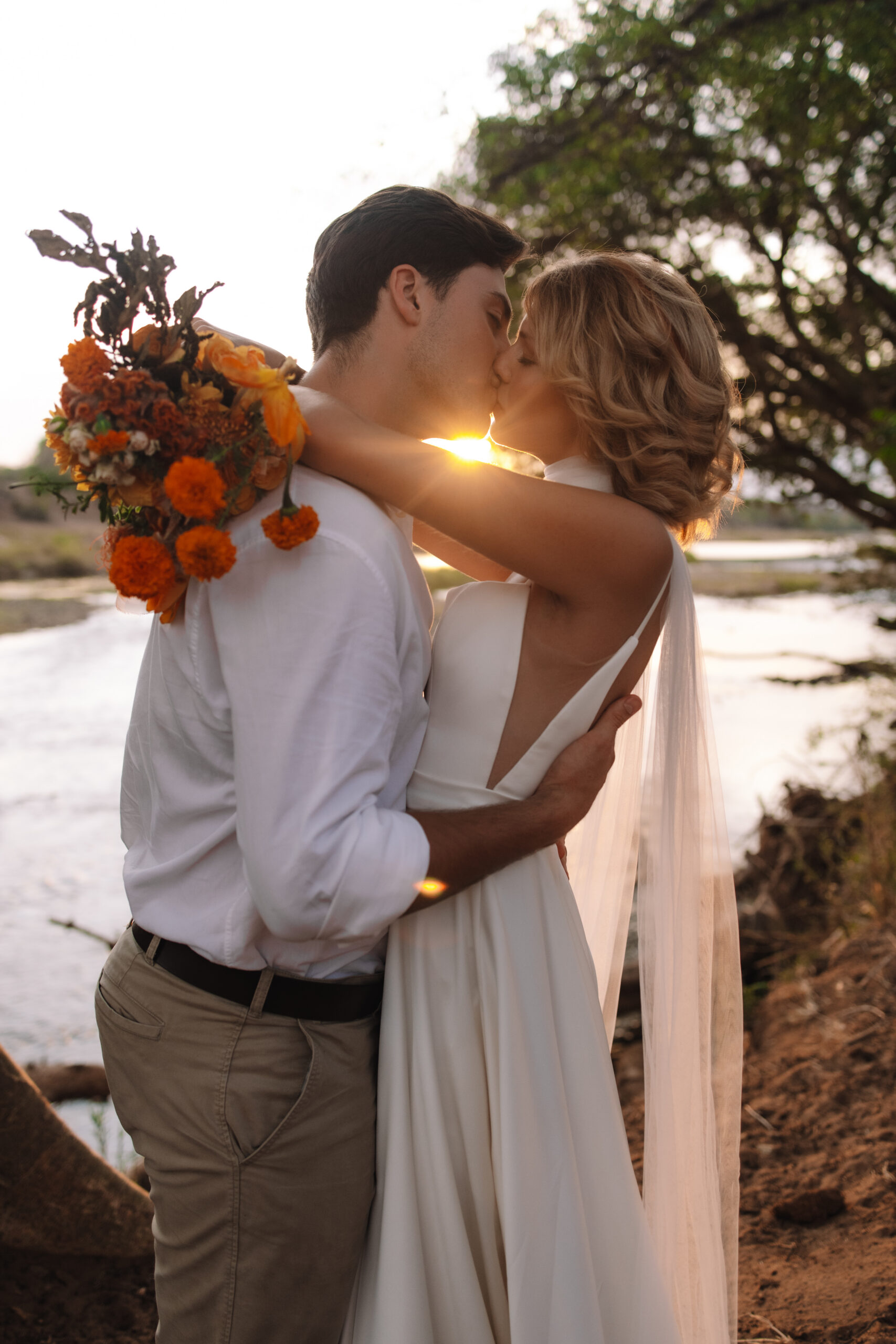 Golden hour kiss by the river during an intimate Cape Town honeymoon.