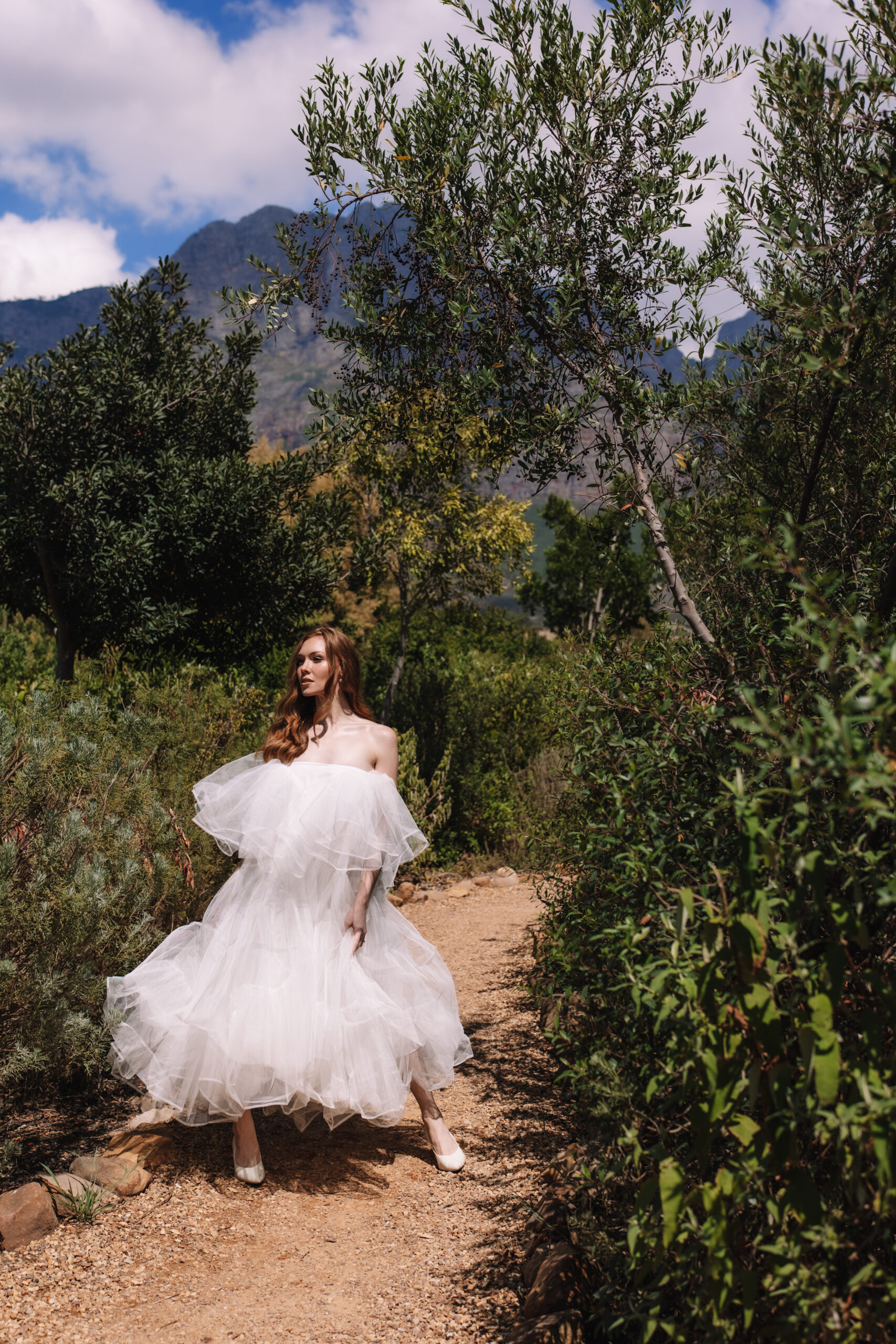 Bride walking through lush greenery in the Cape Winelands during a South Africa elopement.