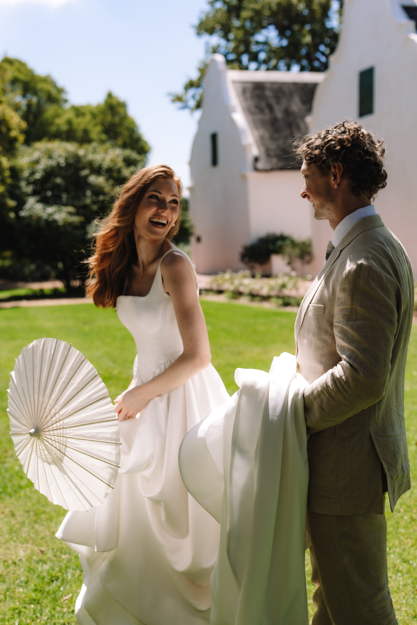 Joyful newlyweds celebrating their Cape Town honeymoon at a Cape Dutch estate.