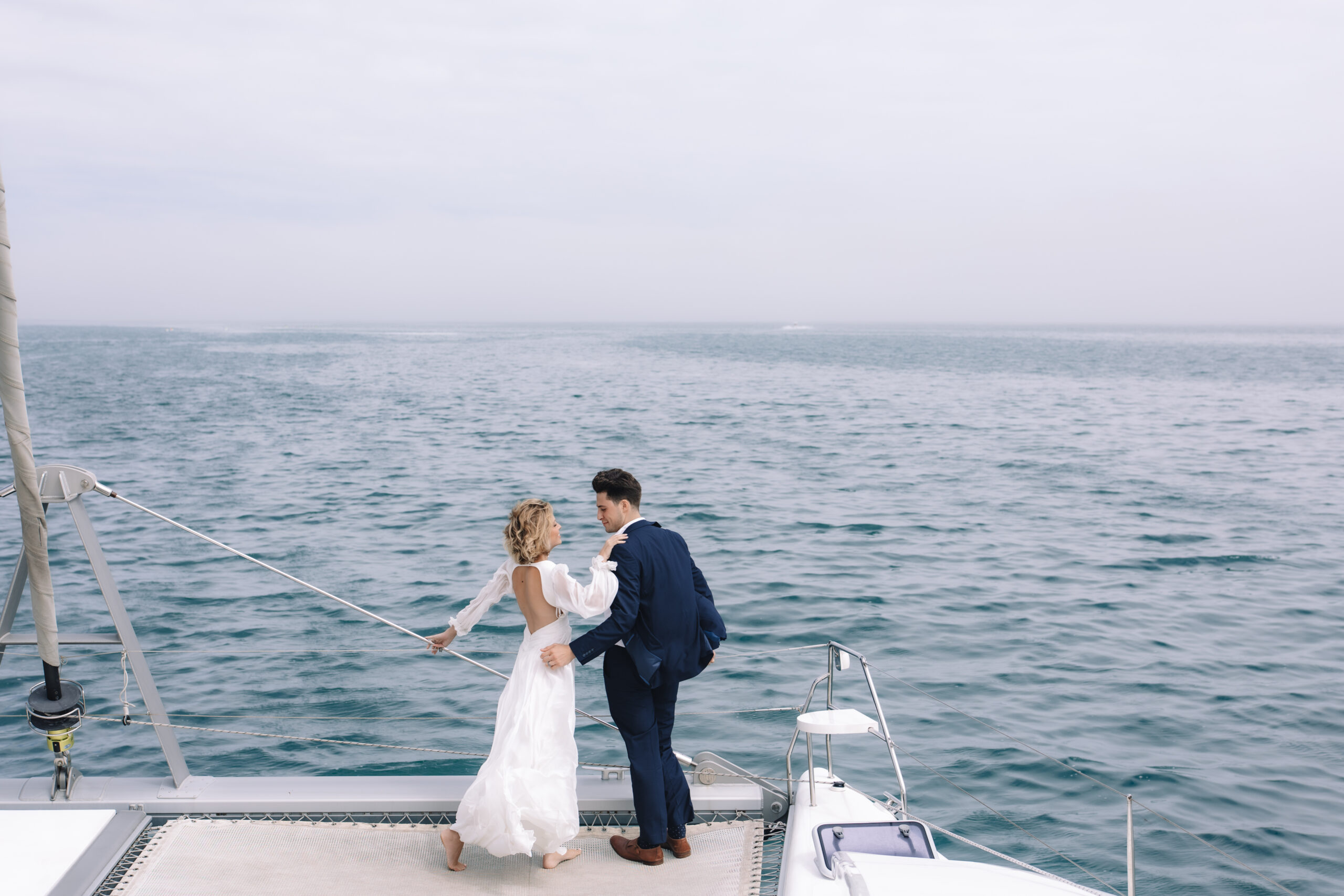 Bride and groom walking barefoot on a yacht during their Cape Town honeymoon.