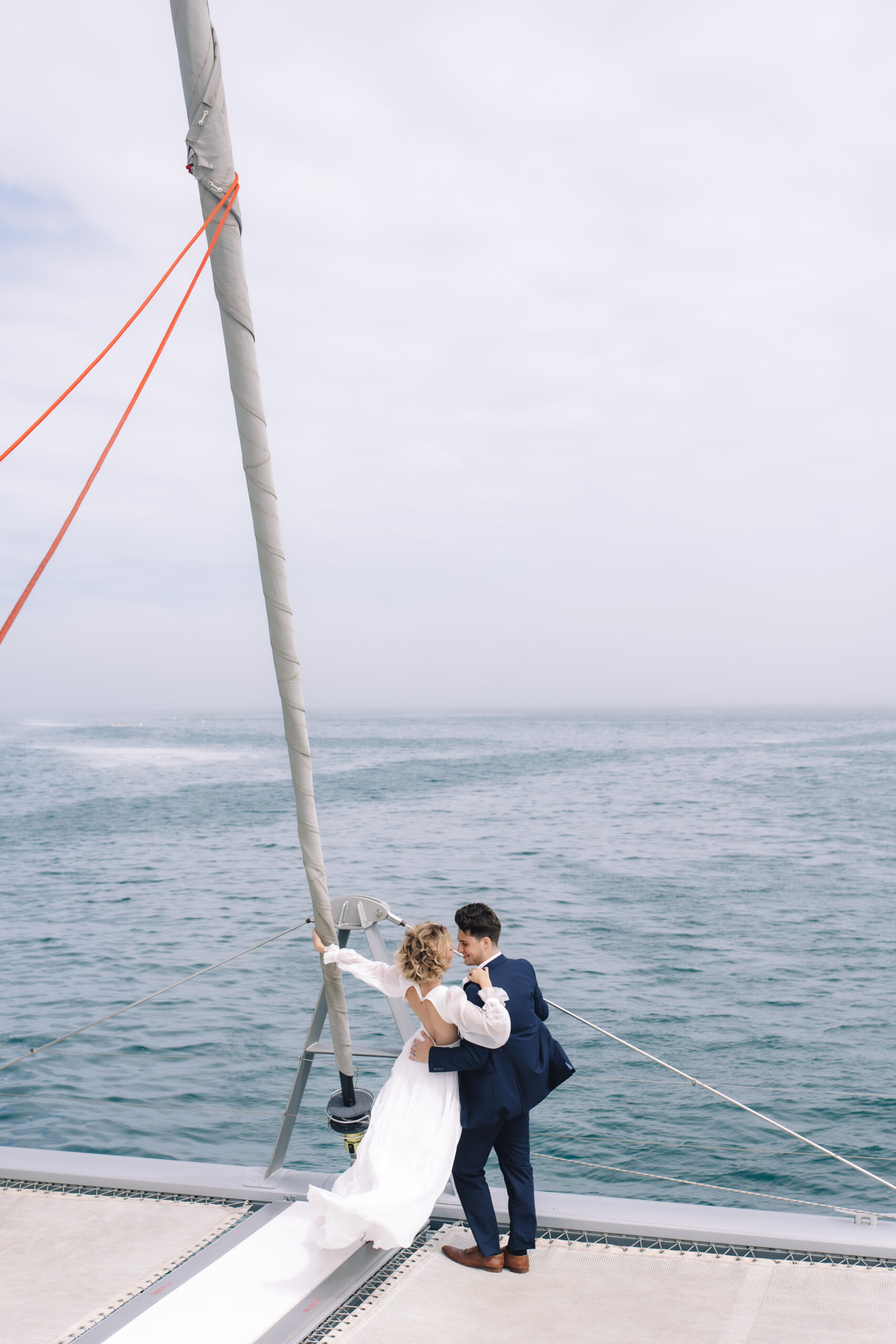 Couple embracing on a sailboat during their Cape Town honeymoon along the South African coast.