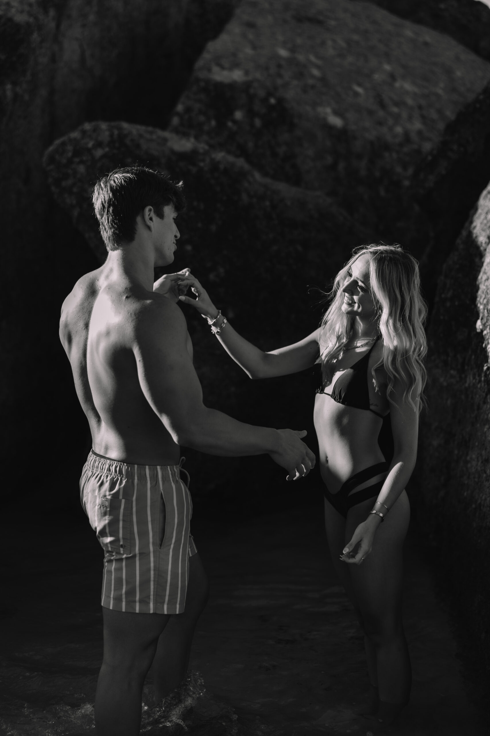 Couple exploring rocky shoreline during their Cape Town honeymoon adventure session.