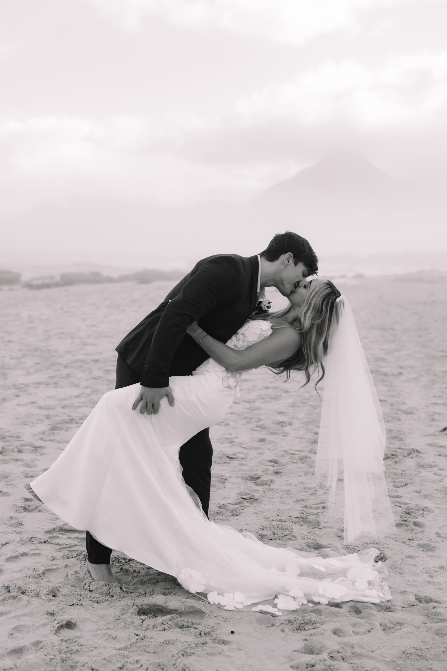 Romantic beach dip photo during a Cape Town honeymoon with dramatic mountain backdrop.