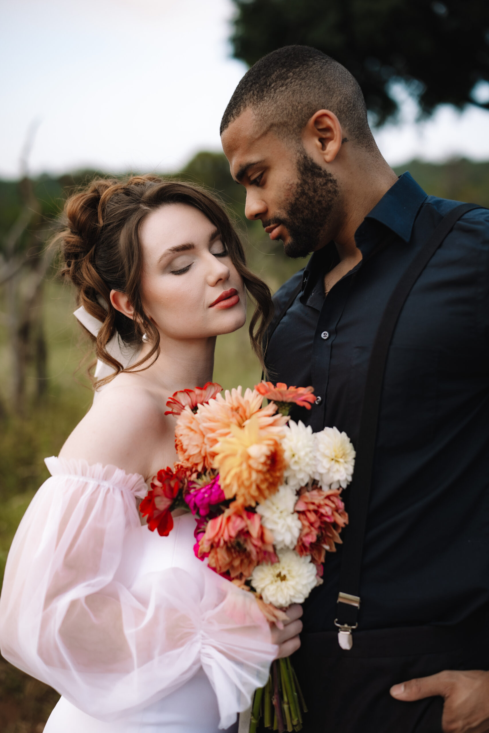 Bride holding a colorful bouquet while standing close with her groom during a safari elopement in Africa